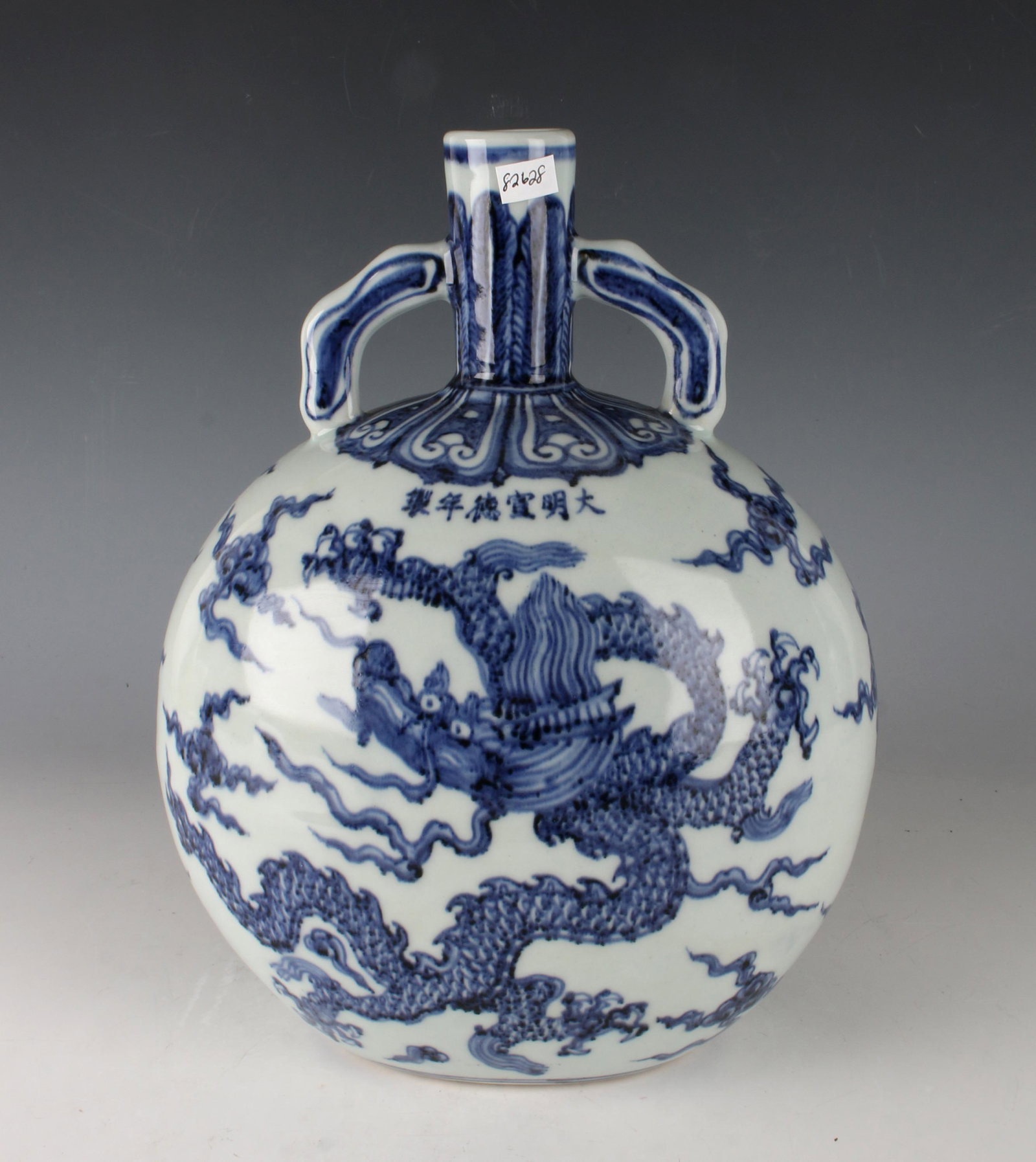 BLUE & WHITE DRAGON MOON FLASK: BLUE & WHITE DRAGON MOON FLASK: The neck has a plantain border flanked by curved open handles. Shoulder has a lotus petal border with a six character mark under it. Dragon on each side of the body