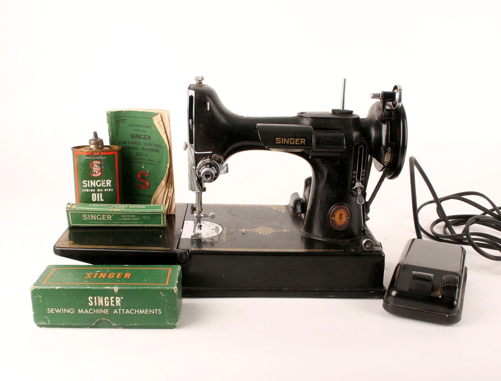 VINTAGE SINGER FEATHERWEIGHT 221 IN ORIGINAL CASE: VINTAGE SINGER FEATHERWEIGHT 221 IN ORIGINAL CASE: Manufacturing date October 26th 1950. 1851 - 1951 Commemorative Feather Weight, in original case, with original manual and attachments. Serial number