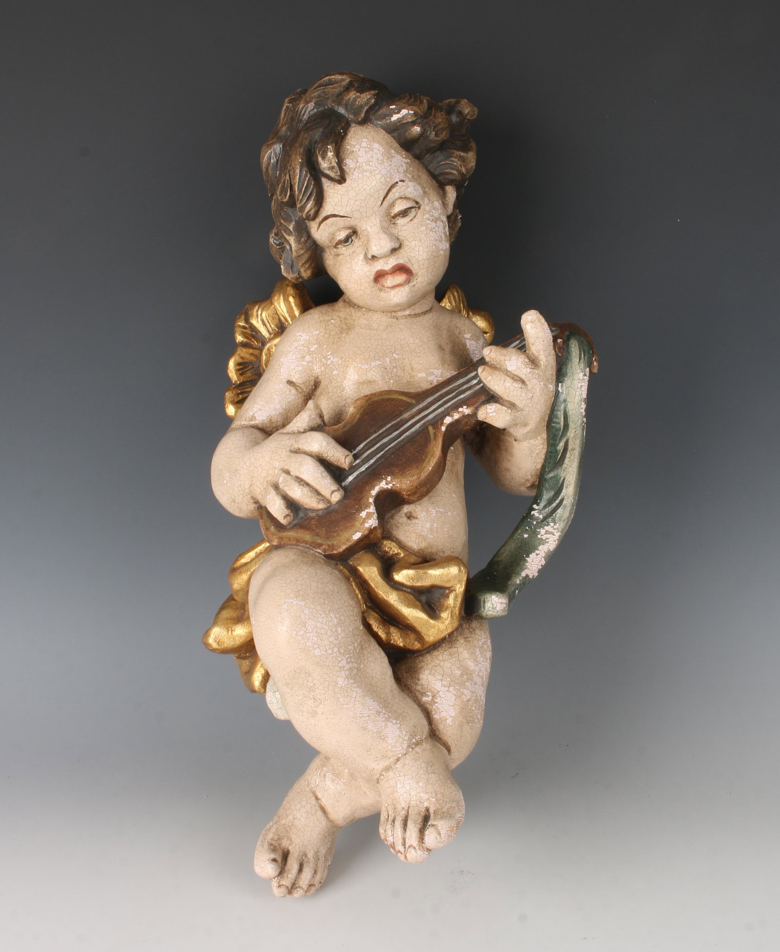 A. KAISER CARVED WOOD GERMAN CHERUB PUTTI: A. KAISER CARVED WOOD GERMAN CHERUB PUTTI: Marked Holz Geschnitzt A. Kaiser am Alten Peter in Munchen Rindermarkt 1. Playing a fiddle. Painted and gilded with an all over craquelure. Wired on the back