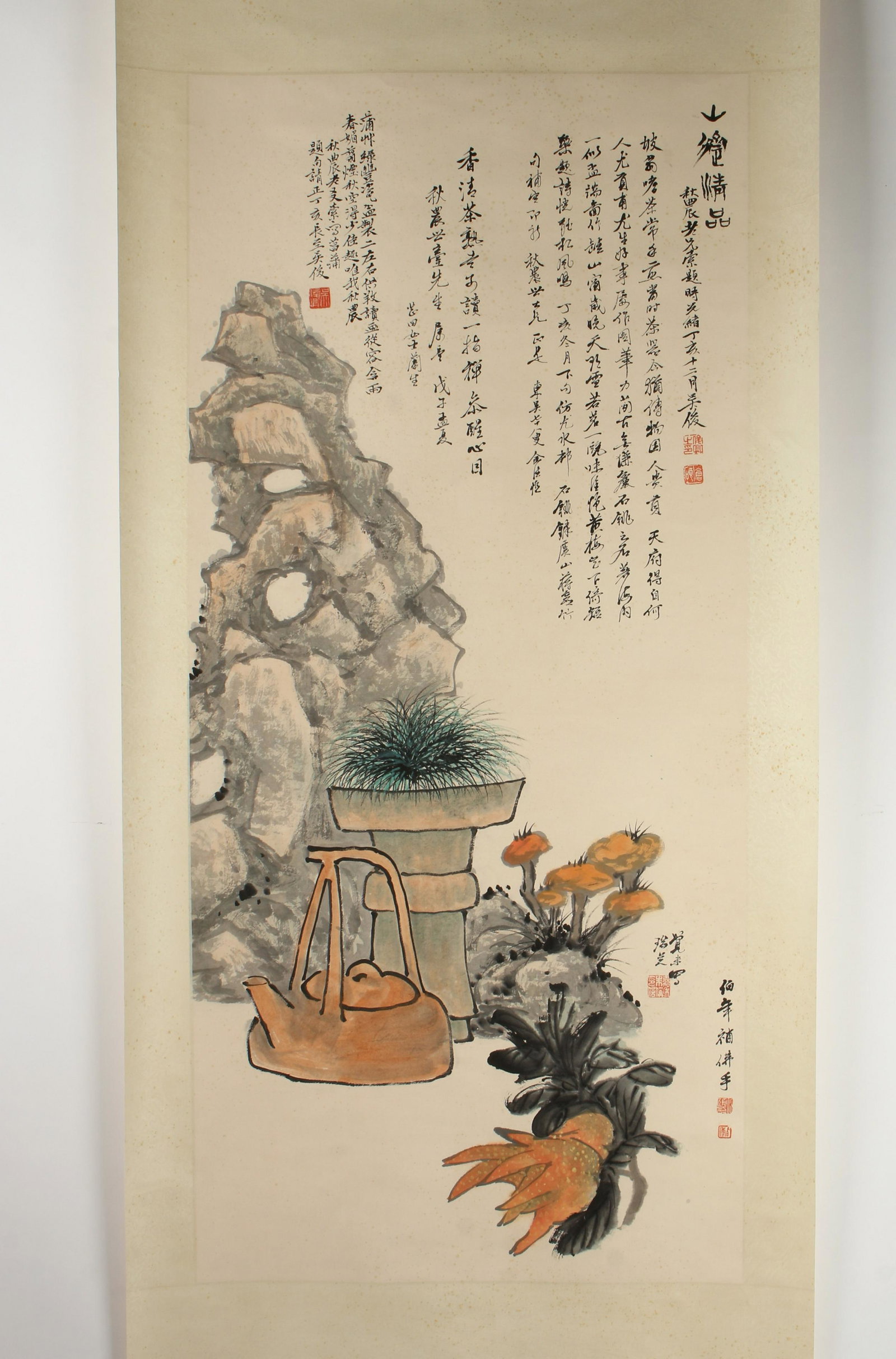 SCROLL STILL LIFE AND PLANTS: SCROLL STILL LIFE AND PLANTS: A large boulder stands behind a potted plant, tea kettle, and hand of Buddha. Calligraphy and artist mark above and lower right. 33 1/2"