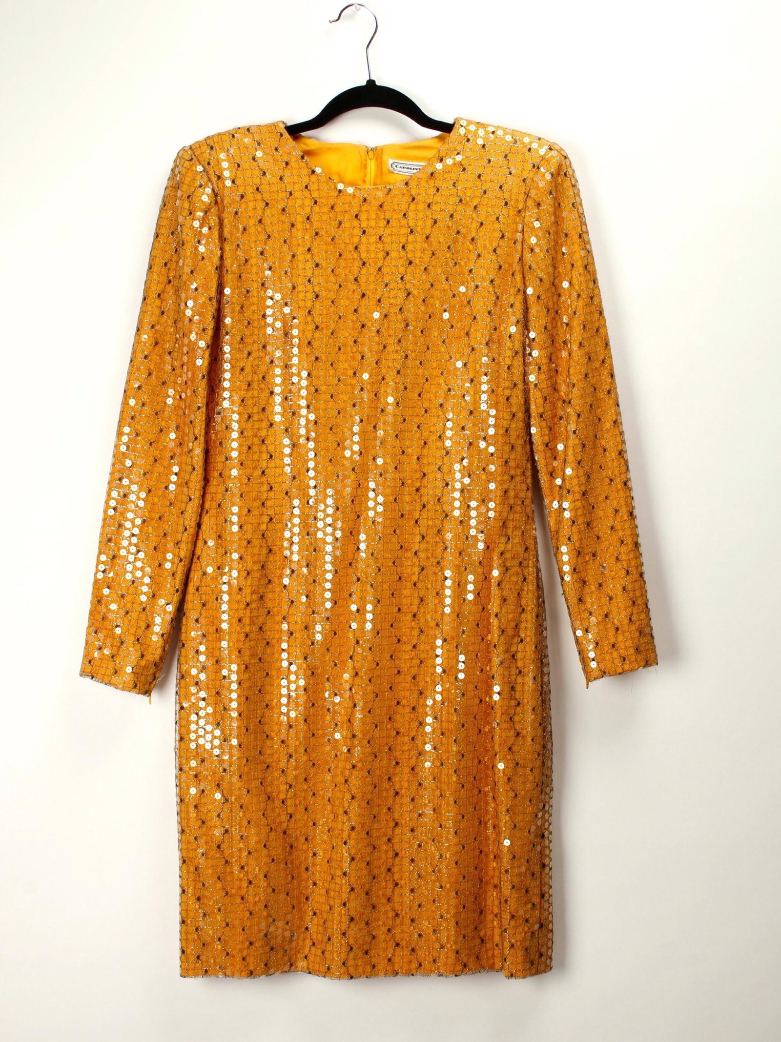 VINTAGE CAROLINA HERRERA GOLD NET COCKTAIL DRESS: Deep gold silk sheath style dress with an overlay of black netting and clear sequins. Has padded shoulders and very slim arms with a zipper wrist closure. Jewel neck, straight slim sleeves. Spot clean