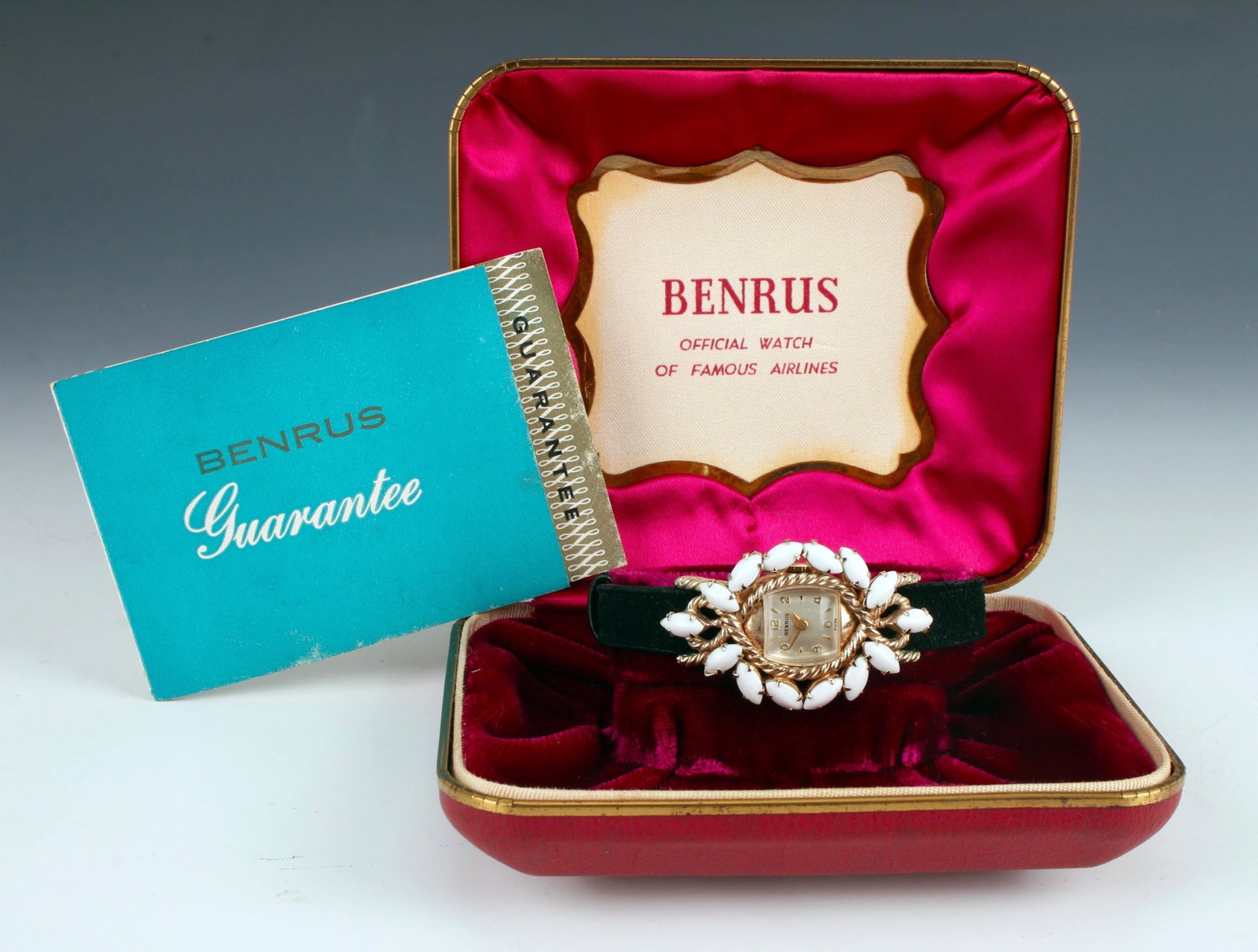 NEW OLD STOCK BENRUS 1960S LADIES WATCH: New old stock Benrus ladies watch in original box with guarantee. Black suede band, the dial is surrounded by white marquee shaped stones. 3" $200 - $400 Please contact us for high resolut