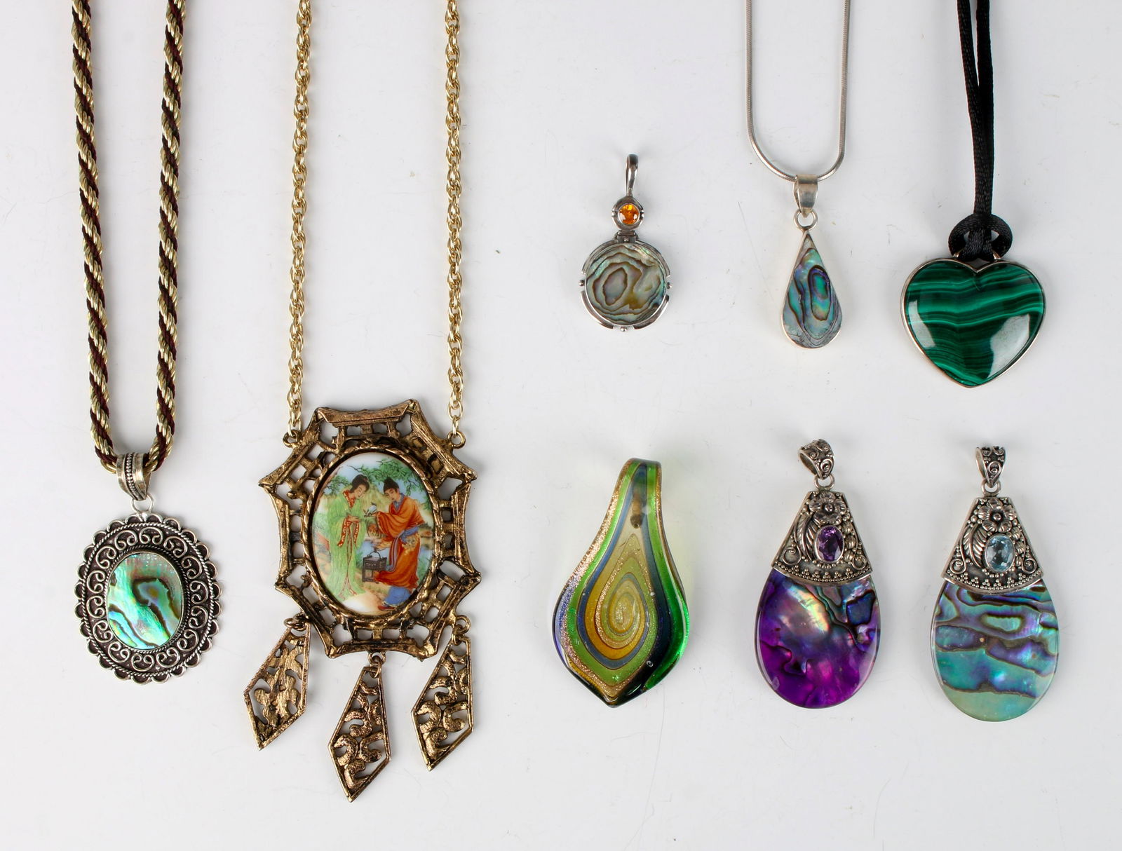 ASSEMBLED LOT OF COSTUME & STERLING PENDANTS: Eight pendants total. Five sterling (four mother of pearl, one Malachite), one blown art glass. Sterling chain on teardrop pendant. $40 - $80 Please contact us for high resolution images of this lot.