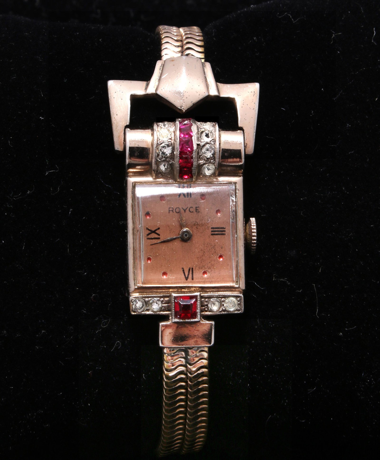 VINTAGE 12K ROSE GOLD ROYCE 1940S WATCH: Vintage 1940s Royce watch is set with faux rubies and diamonds and has a copper dial. Original. $200 - $400 Please contact us for high resolution images of this lot. Shipping: We are able to
