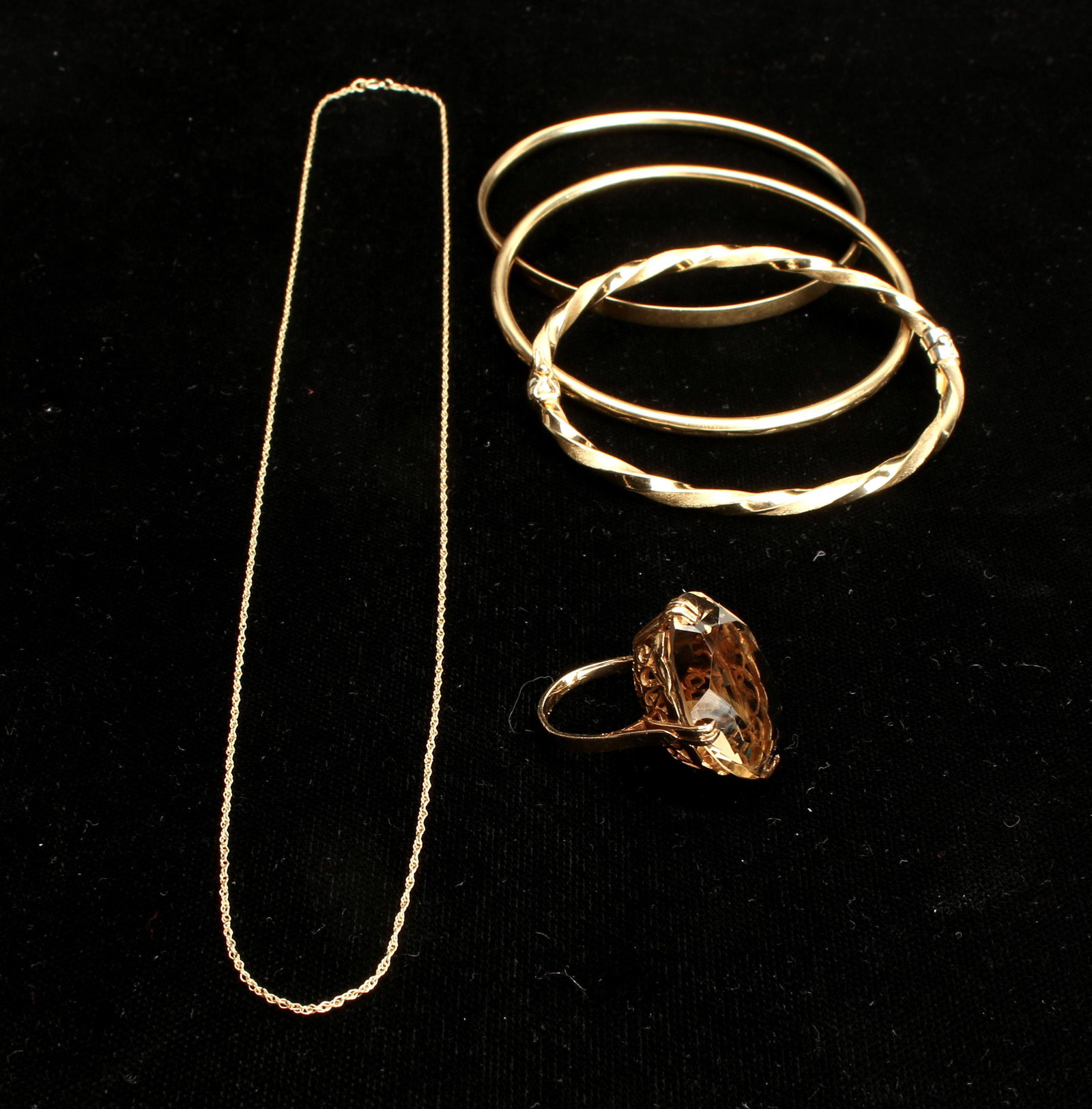 14K LOT OF GOLD BANGLES, BRACELET, RING, CHAIN: Large marquise faceted smoky quartz set on basket form ring in 14K YG, twisted hinged bracelet in brushed and bright finish, 2 bangle bracelets, and delicate link chain included in this assembled lot.