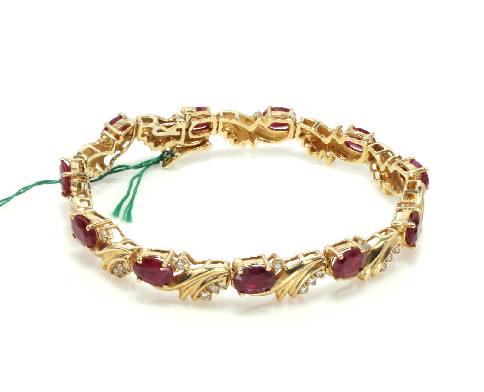 FINE RUBY & DIAMOND YELLOW GOLD BRACELET: Eleven oval faceted rubies each on a separate link with four diamonds. Tongue and safety clasp. Ruby 10ct total weight. New fine jewelry from 2nd generation Texa