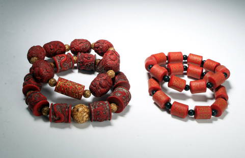 4 CHINESE CARVED BEAD BRACELETS: One pair of them have tiny incised calligraphy on the cinnabar colored beads, they alternate with black rounds beads. The other pair are barrel shaped carved with dragons and phoenixes.  $40 - $80 Ple