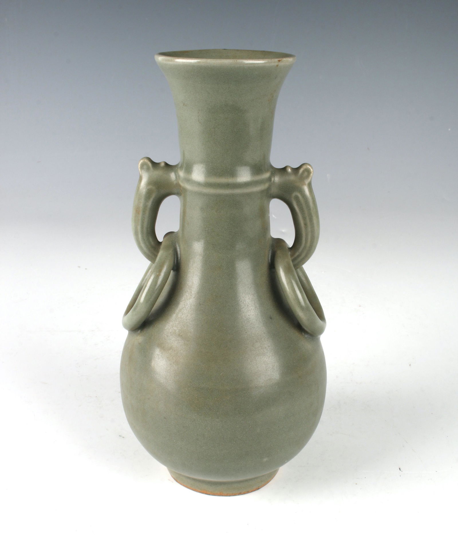 CELADON VASE WITH HANDLES: Small pear shaped porcelain celadon vase with looped handles and attached rings. 7" X 3" $200 - $400 Please contact us for high resolution images of this lot. Shipping: