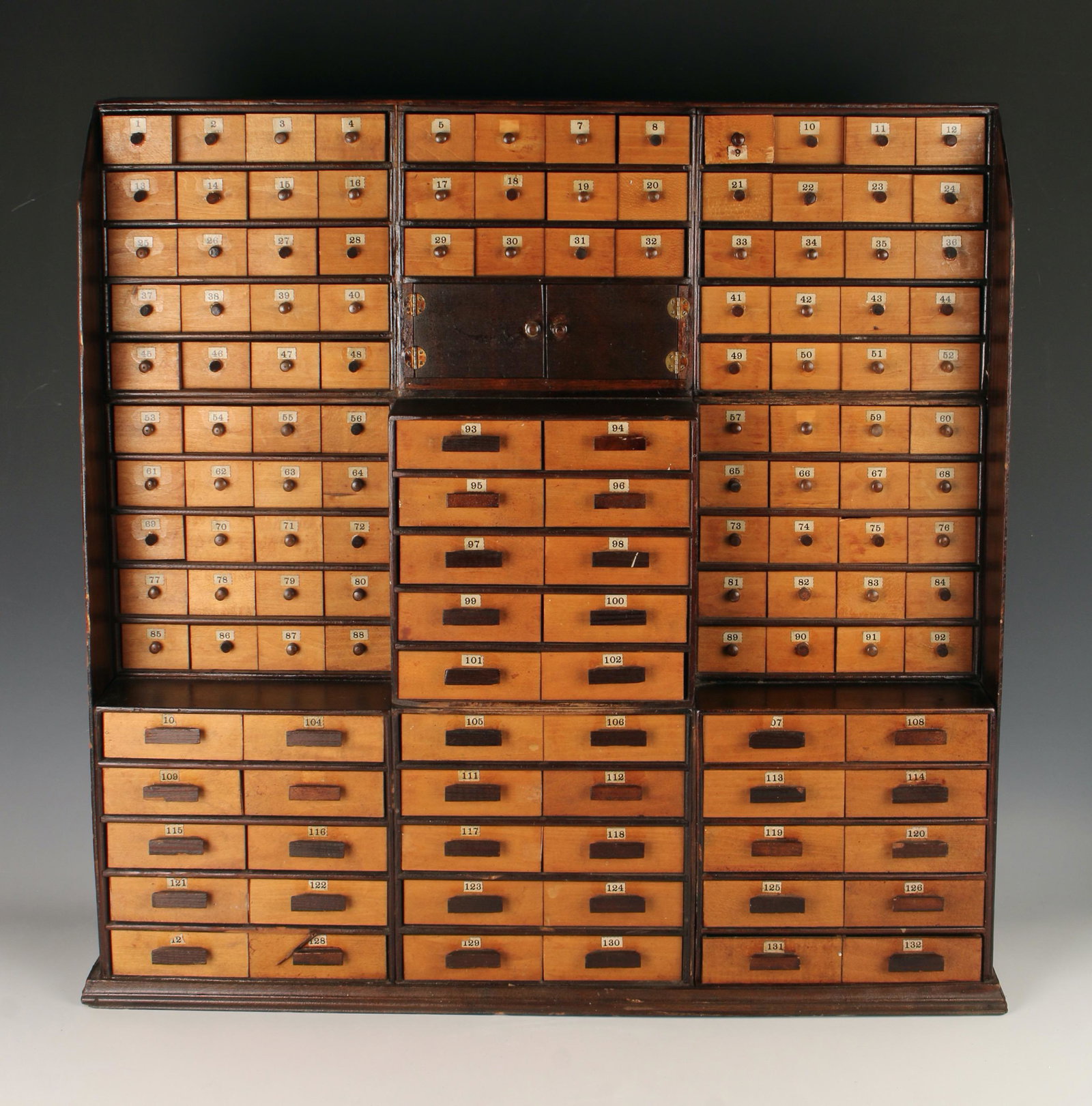 APOTHECARY DRY GOODS TABLE TOP CABINET: Drawers are numbered 1 - 132 in addition to which there is a central two door compartment in the middle. 26" x 26" x 5.5" $600 - $900 Please contact us for high resolution images