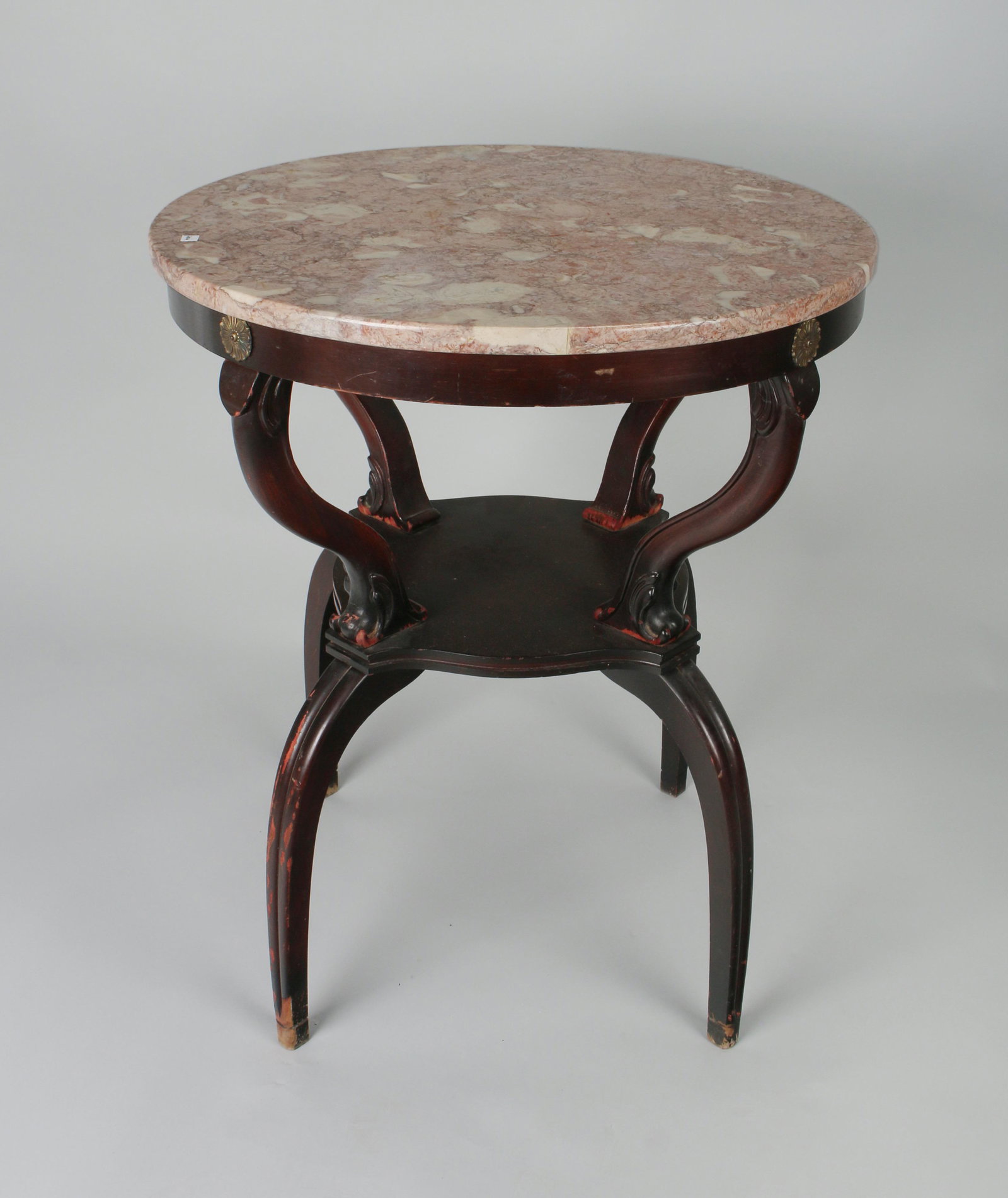 VINTAGE MARBLE TOP TABLE 1940S: Brass rosettes are placed at the top of the supported brackets. Stands on four arched legs. 29" X 24" $100 - $200 Please contact us for high resolution images of this lot. Shipp
