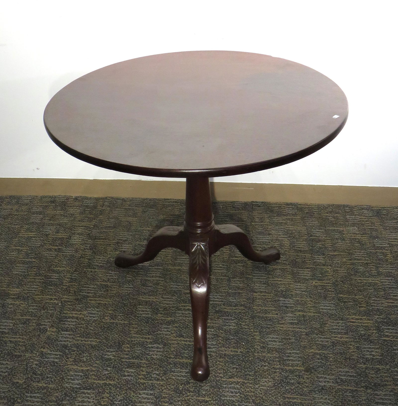 GEORGIAN TILT TOP BIRDCAGE TEA TABLE: A solid mahogany Georgian carved table featuring a turned central support with three snake feet. 26 1/2" X 30 1/2" (tilted 44" X 30 1/2") $300 - $500 Please contact us for