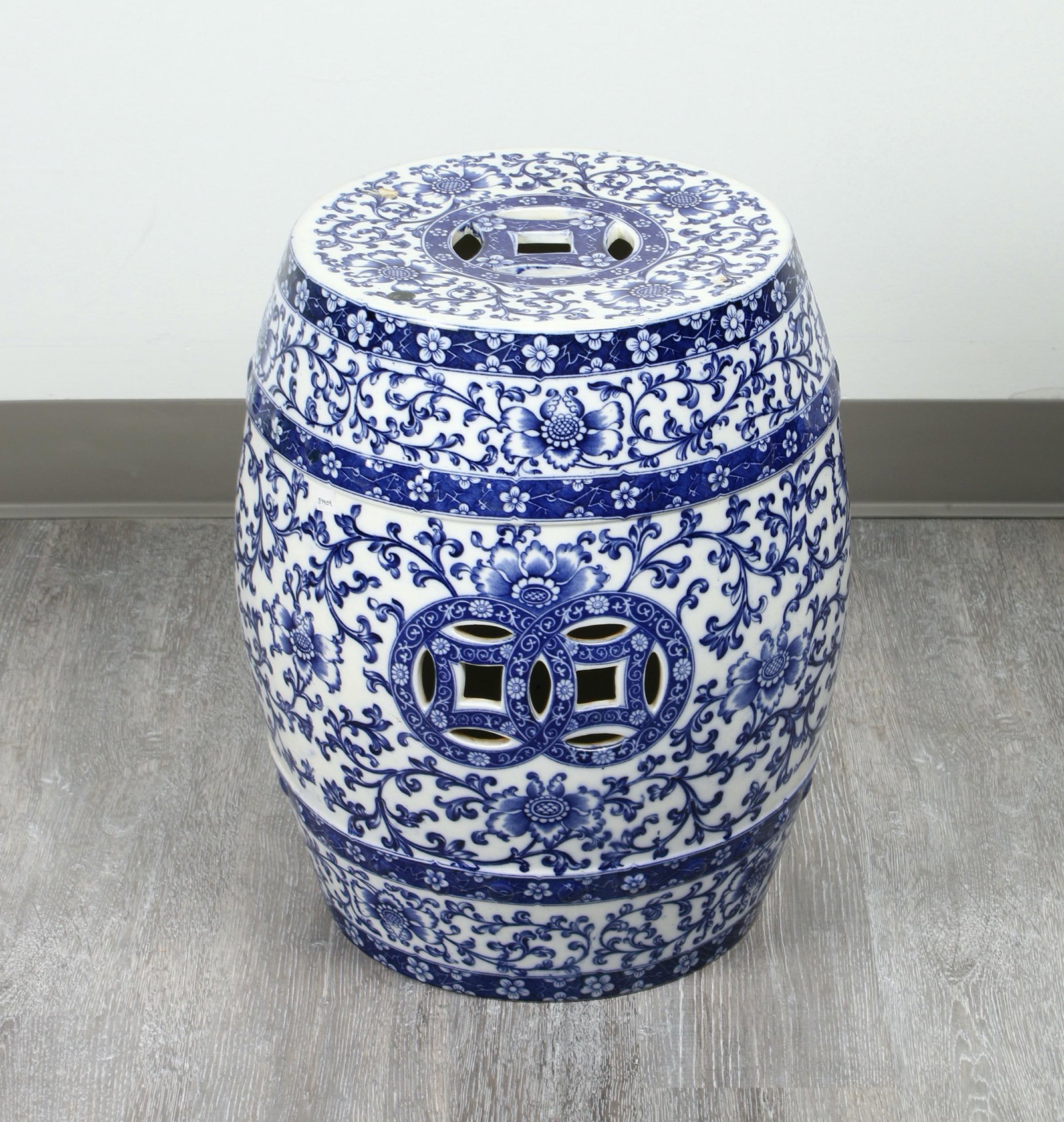 BLUE AND WHITE PORCELAIN GARDEN STOOL: Pierced lucky coins and flower and tendrils designs. 14" x 18.5" $100 - $200 Please contact us for high resolution images of this lot. Shipping: We are a