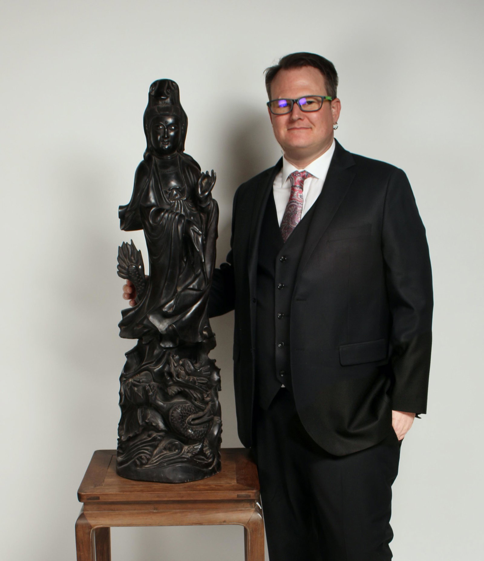 TALL CARVED ZITAN GUAN YIN: The Quan Yin is standing, draped in robes, on a pedestal of waves and lily pads. A dragon surrounds the pedestal with its mouth agape. She's pouring the contents of a bottle into the waves while her o