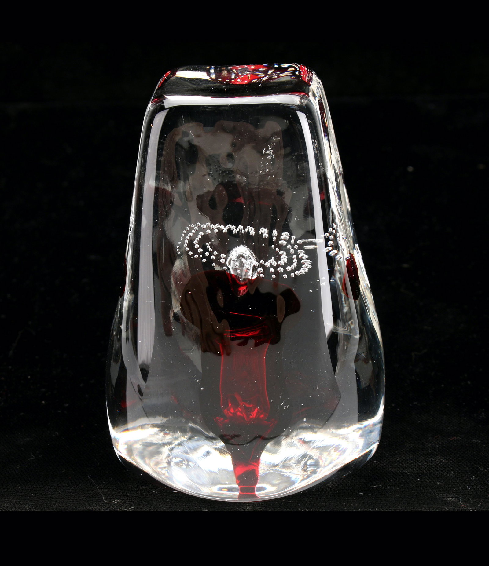 SIGNED GRANT ART GLASS PAPERWEIGHT: Art glass paperweight with refined controlled bubble pattern floating above a deep red flower. Signed Grant '95. The bottom is circular and rises to a soft square form at the top. 2 1/2" X 4"