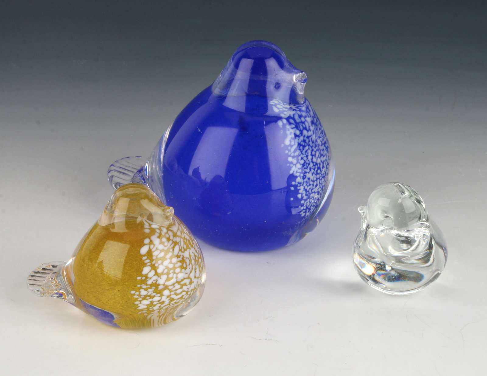 MCM THREE BLOWN GLASS BIRDS: The smallest one is clear, the mid sized one is yellow with white spatters, the largest is blue with white spatters. Most likely made in Norway. 3" $100 - $200 Please contact us for high r