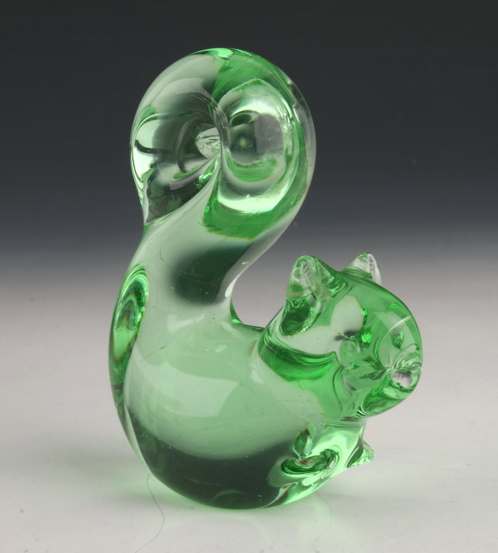 GREEN BLOWN GLASS SQUIRREL: The squirrel is sitting up with tall curled tail and front paws below raised. 3" $100 - $200 Please contact us for high resolution images of this lot. Shipping: