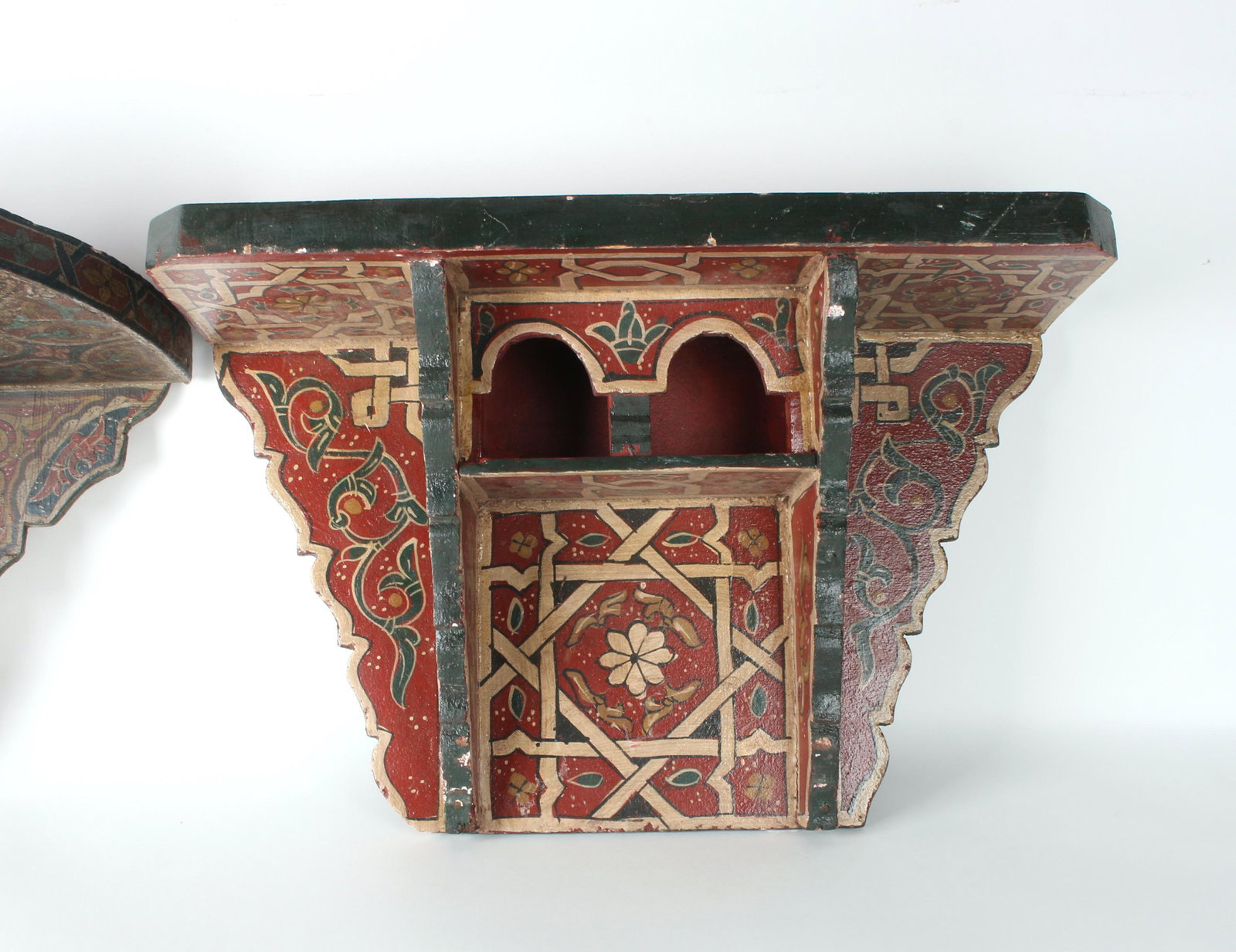2 CARVED & PAINTED SCONCE SHELVES: Carved and painted sconce shelves, possibly Middle Eastern. The one that is mostly red has a top gallery area. The one that is primarily painted in darker shades has a lower shelf area. 20" X 13&
