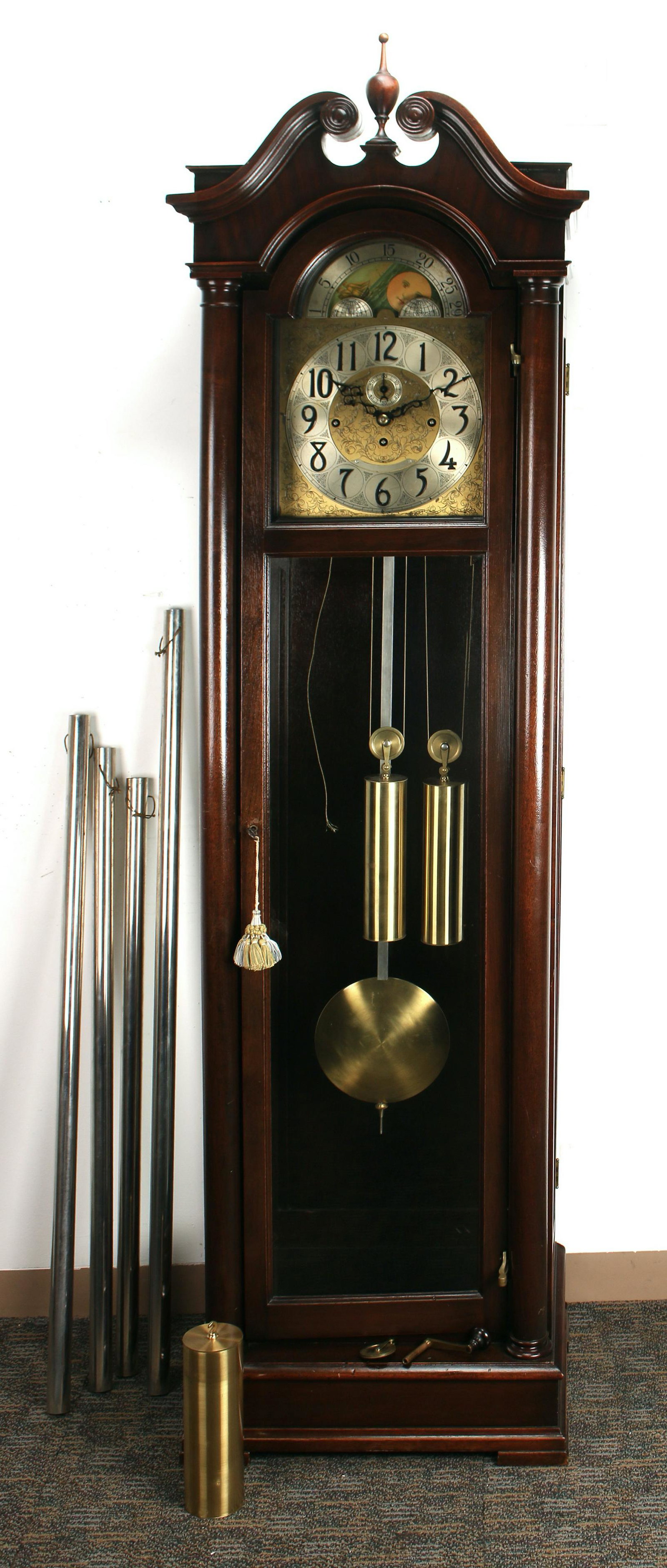 HERSCHEDE HALL CLOCK: Including pendulum, weights, and key. This is a tubular chime clock with four tubes, three weights, a pendulum, and a key. The top has a broke arch, the case has glass side doors. 78" $500 - $8