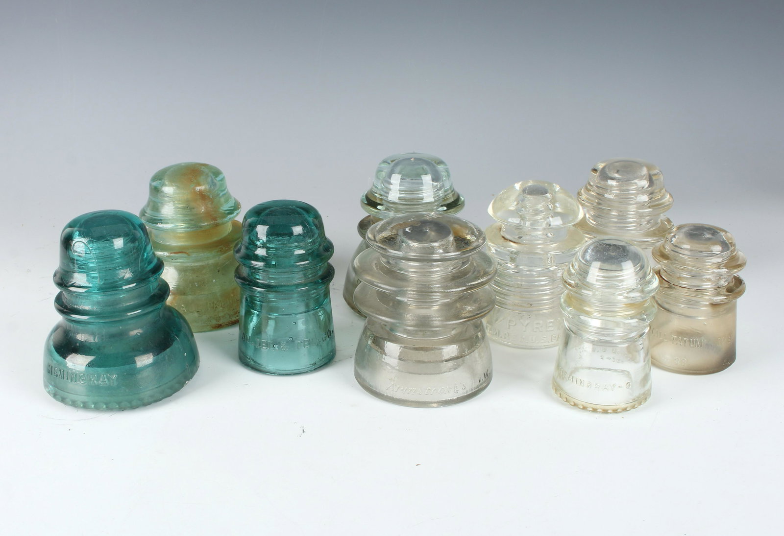ASSEMBLED LOT OF 9 GLASS INSULATORS: Pyrex, Armstrong's, Hemingray-17, Hemingray-42, Hemingray-9, Whitall-Tatum 33 in clear. Blue ones are Am. Tel. & Tel. Co., Whitall-Tatum 1, and Hemingray-40. $100 - $200 Please contact us for high