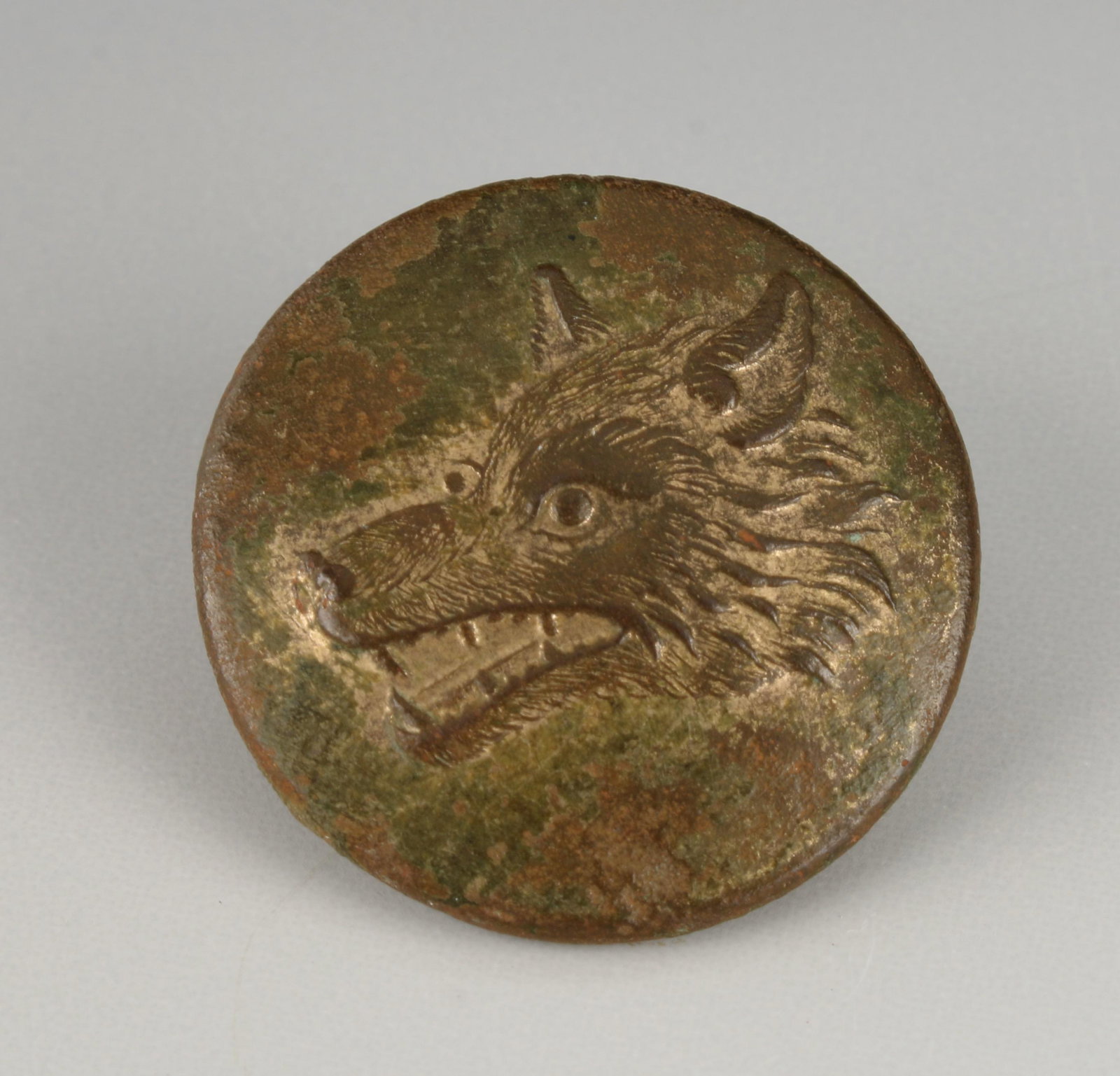 19TH CENTURY BRONZE WOLF BUTTON: Snarling wolf on a bronze button. The North Remembers! 3/4" $100 - $200 Please contact us for high resolution images of this lot. Shipping: We are able to pack