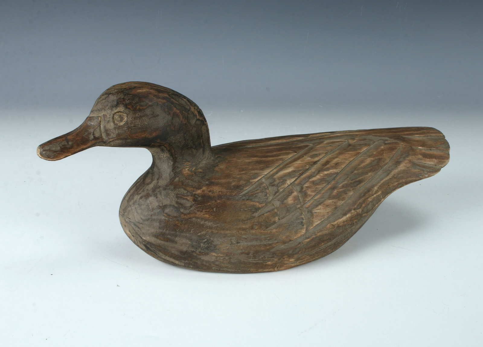 HAND CARVED DUCK DECOY: Signed in script on the bottom J. P(?). Purposefully rough hewn duck retaining chisel marks. With carved and incised details. 12" $100 - $200 Please contact us for high resolution images o