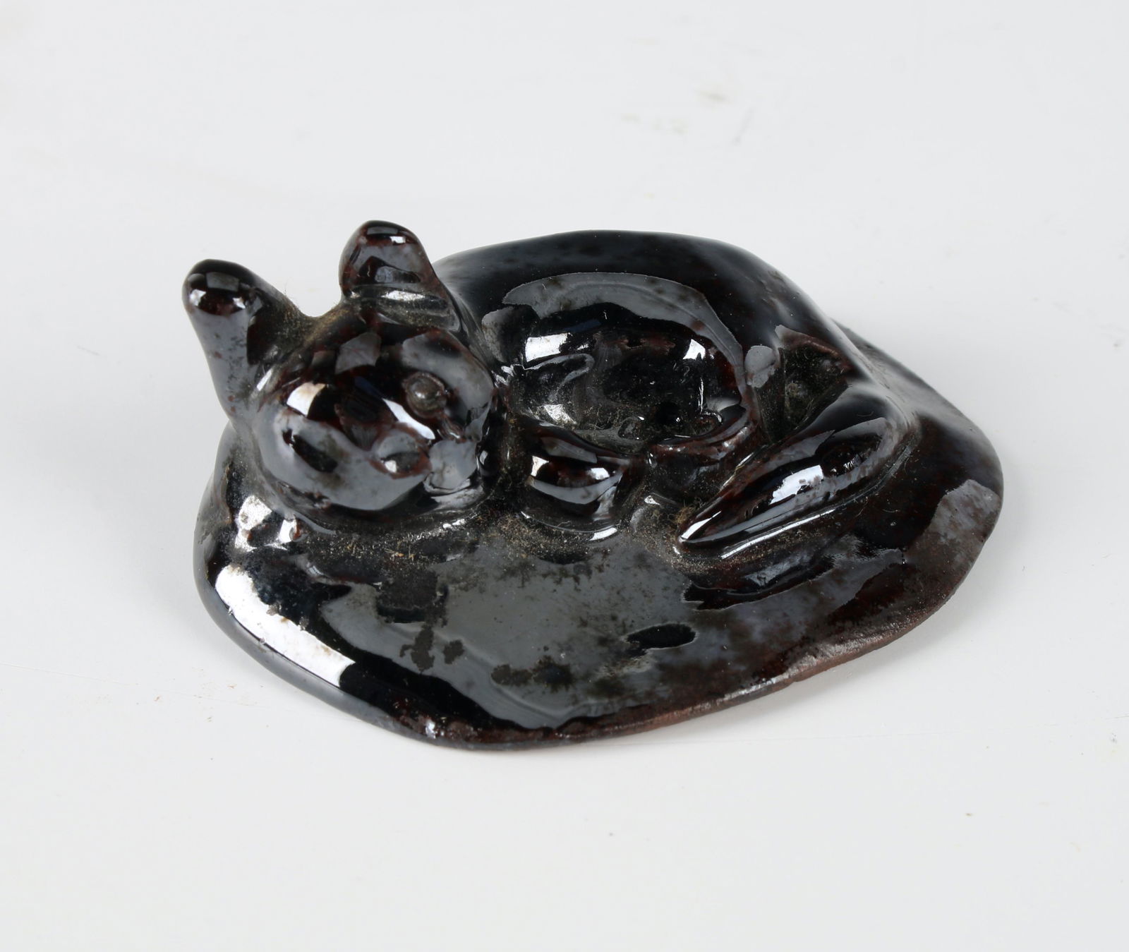 MINIATURE FOLK ART REDWARE CAT: Unsigned. A lounging cat in a dark luster glaze. 2" $40 - $80 Please contact us for high resolution images of this lot. Shipping: We are able to pack and ship