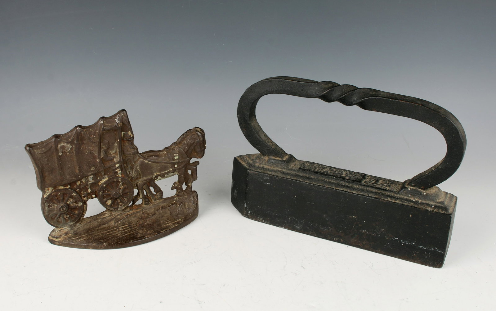 ANTIQUE 12 POUND IRON AND BOOKEND: This heavy forged iron has a distinctive twisted handle and is stamped 12 (lb) on the top. The bookend/doorstop is in the form of a covered wagon and is marked on the back. 9 1/2" X 6" $40