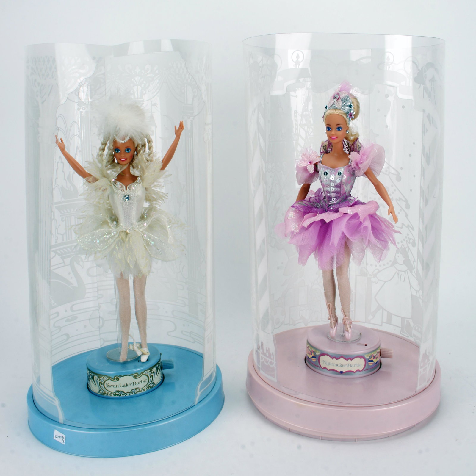 PAIR OF BALLET BARBIES WITH MUSIC BOXES: With acetate backdrops and a proscenium arch openings. Swan Queen with blue music box base and the Nutcracker dancer with a pink music box base. 10 1/2" X 19" $40 - $80 Please contact