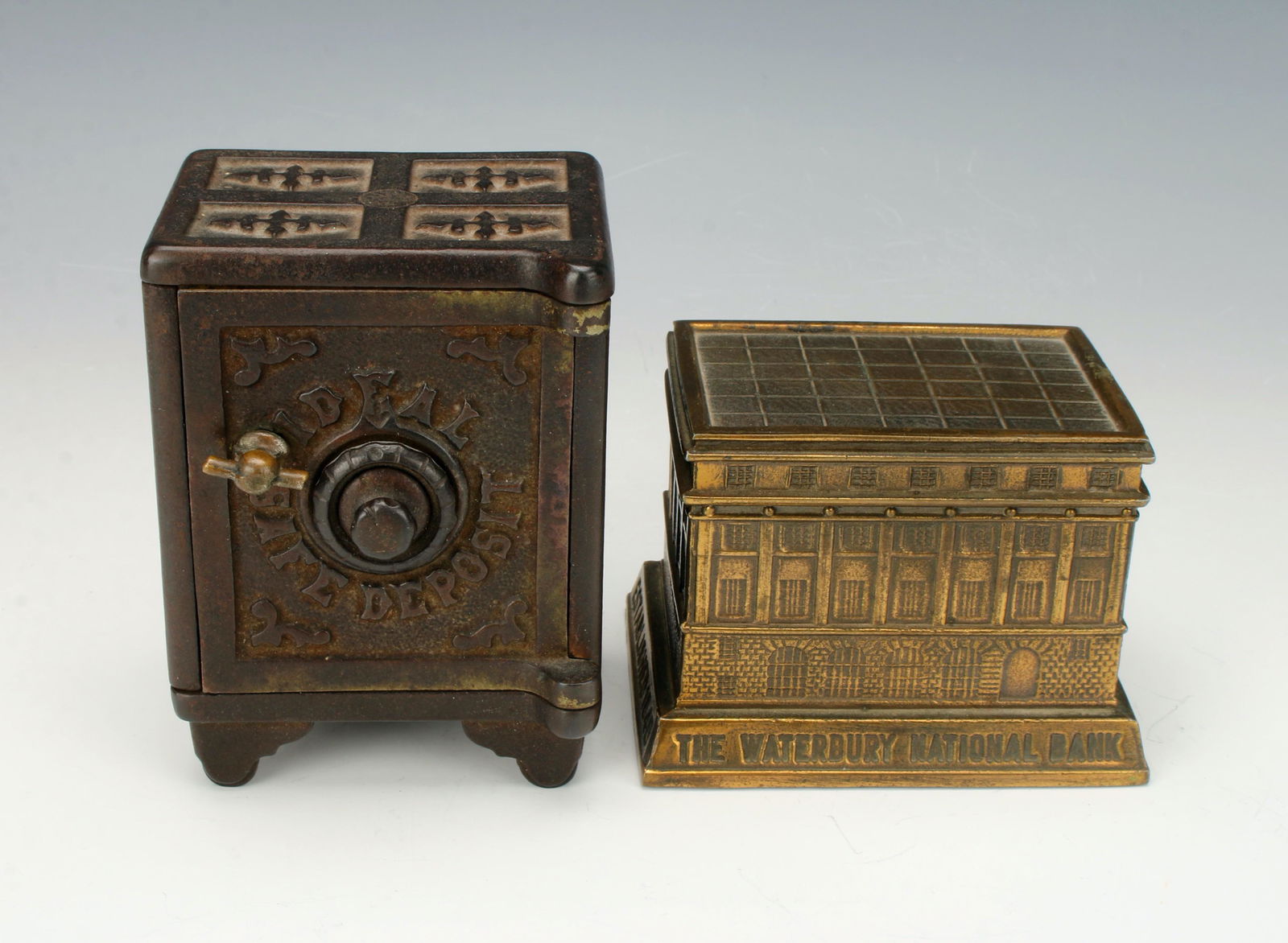TWO VINTAGE METAL COIN BANKS: Cast iron bank 'Ideal Safe Deposit Box' in shape of safe with combination dial. Banthrico brass coated metal coin bank marked Waterbury, CT. 4" X 3" X 2 1/4" $40 - $80 Please cont
