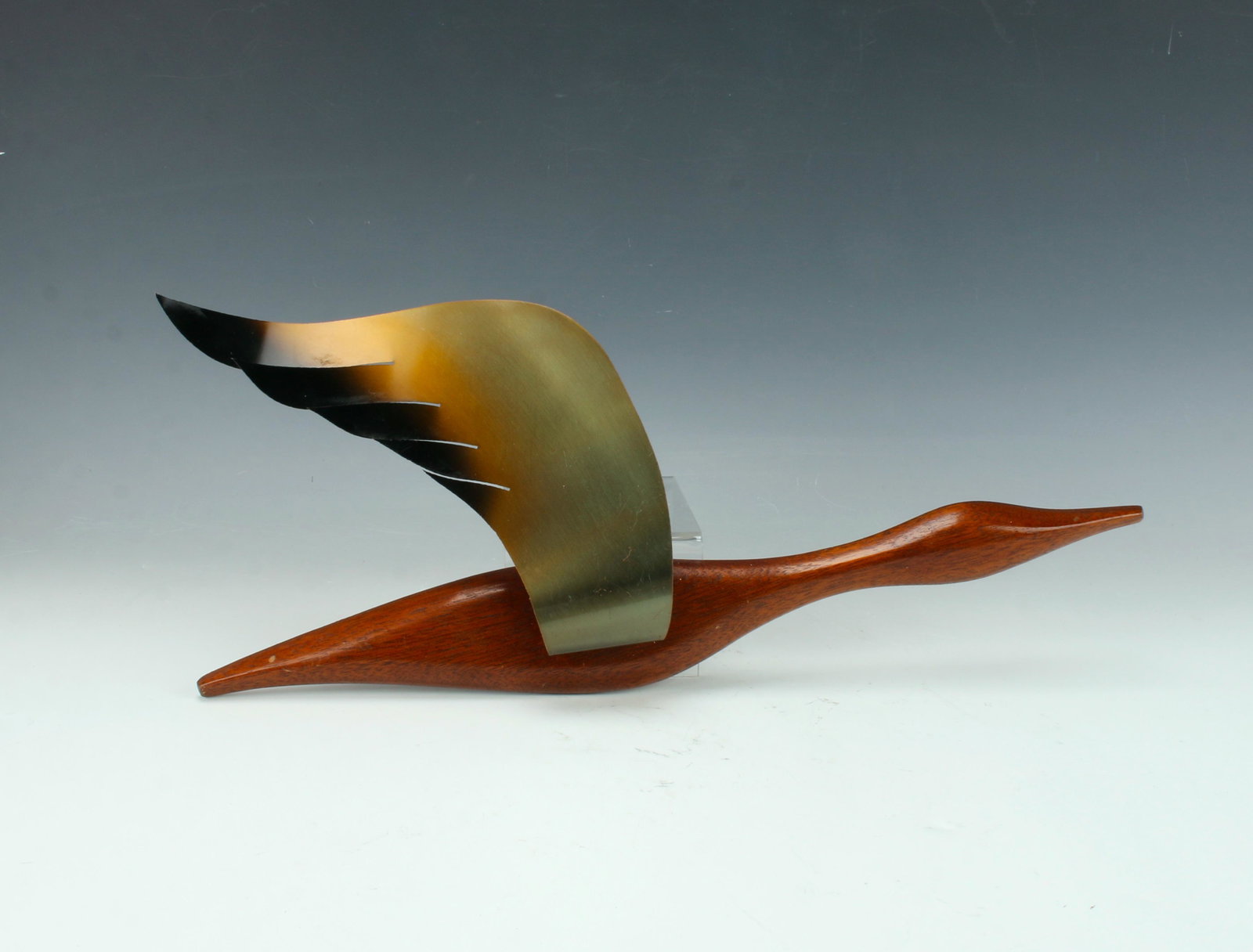 MCM FLYING GOOSE WALL PLAQUE: Sleek flying goose with polished wooden body and patina-ed sheet metal wing. 15" X 7" $40 - $80 Please contact us for high resolution images of this lot. Shipping: