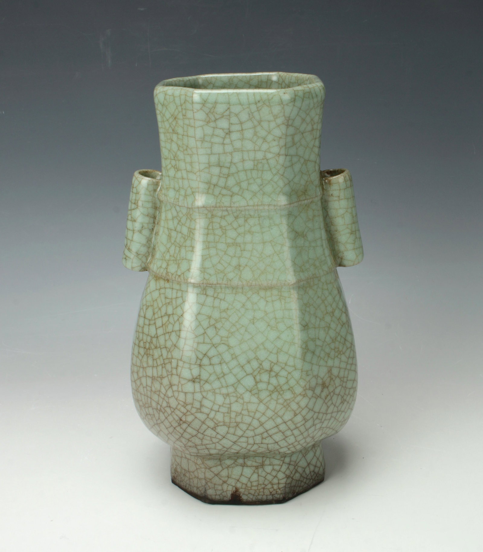 PORCELAIN HEXAGONAL CELADON CRACKLE VASE: Tubular handles with two ridges around the neck. All over craquelure glaze. Two pierced holes on the raised foot. Provenance: private collec