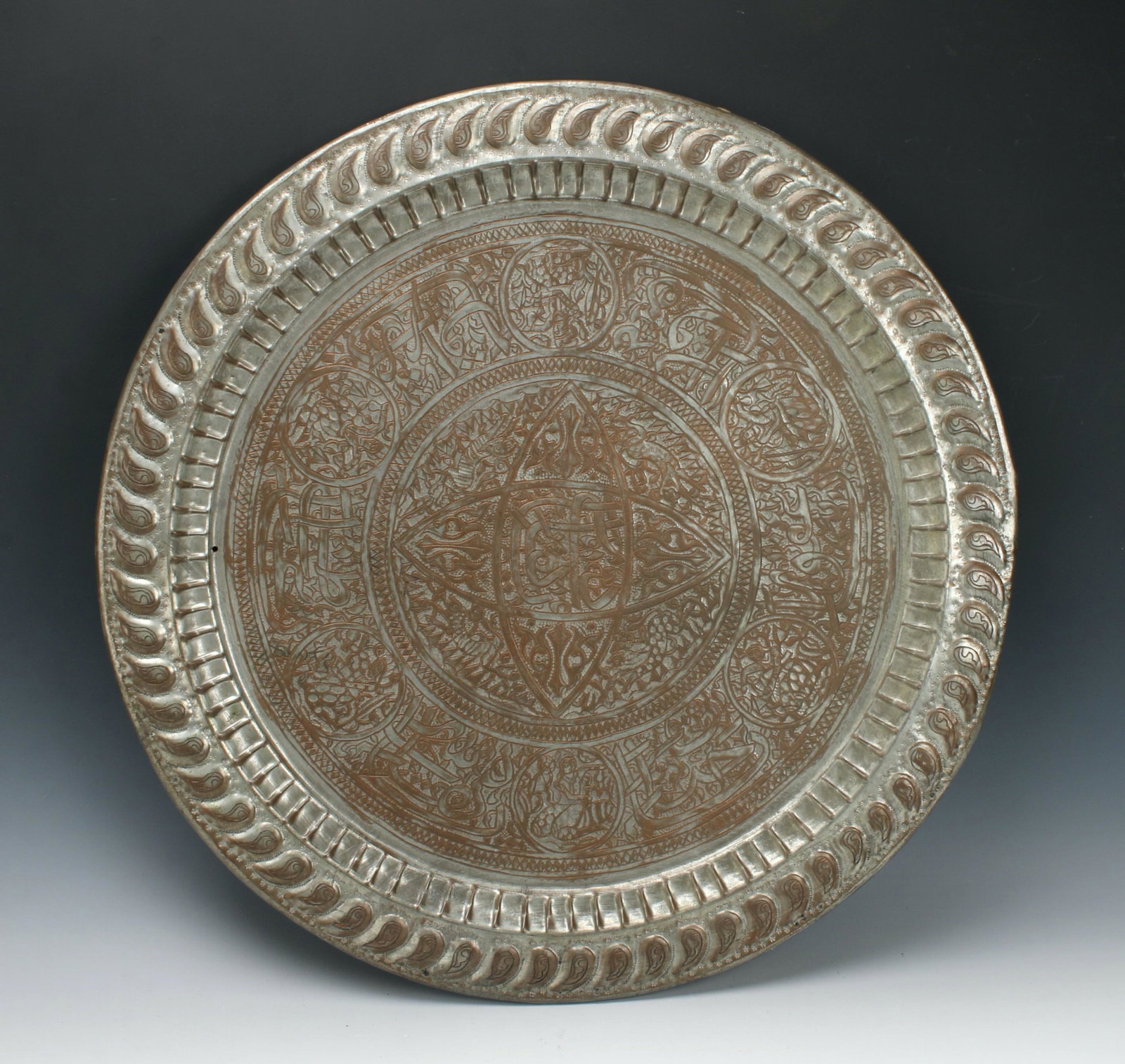 LARGE DECORATIVE BRASS TABLE TOP TRAY: Highly figured with calligraphy, figures, and paisley patterns. Possibly Middle Eastern. 25" x 1" $100 - $200 Please contact us for high resolution images of this lot. Shipping