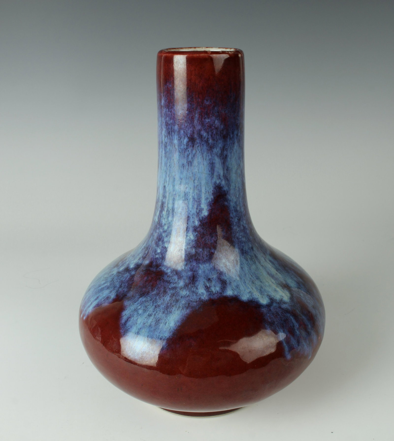 CHINESE FLAMBE GLAZE BOTTLE VASE: Flambe glaze with blues and ox blood. Marked on bottom. 6 1/2" X 9" $100 - $200 Please contact us for high resolution images of this lot. Shipping: We ar