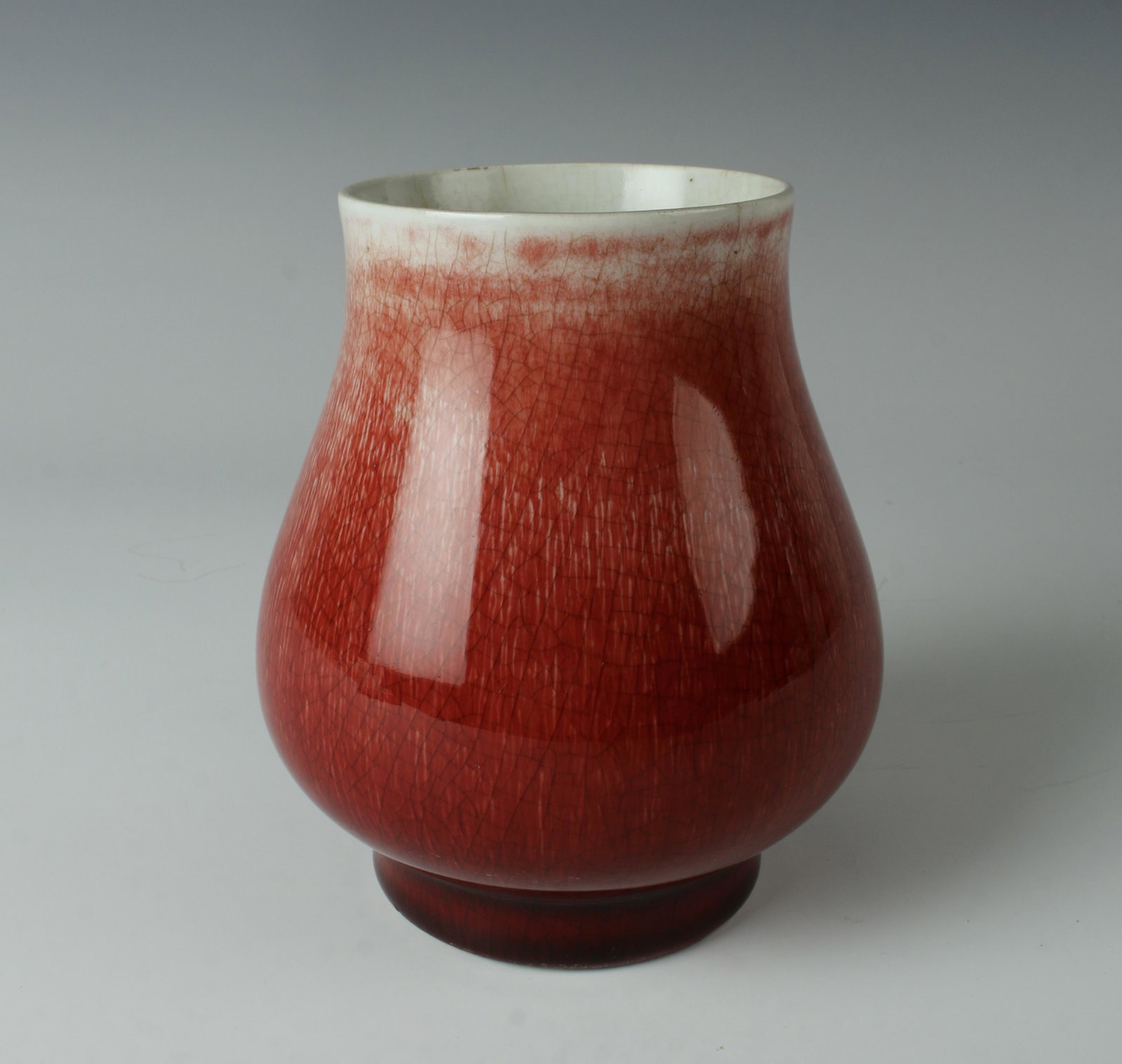 CHINESE OX BLOOD SQUAT GRADATING VASE: Gradates from pale celadon at the top to dark ox blood at the bottom. With a subtle craquelure underneath. 4 1/2" X 5 1/4" $200 - $400 Please contact us for high resolution images of