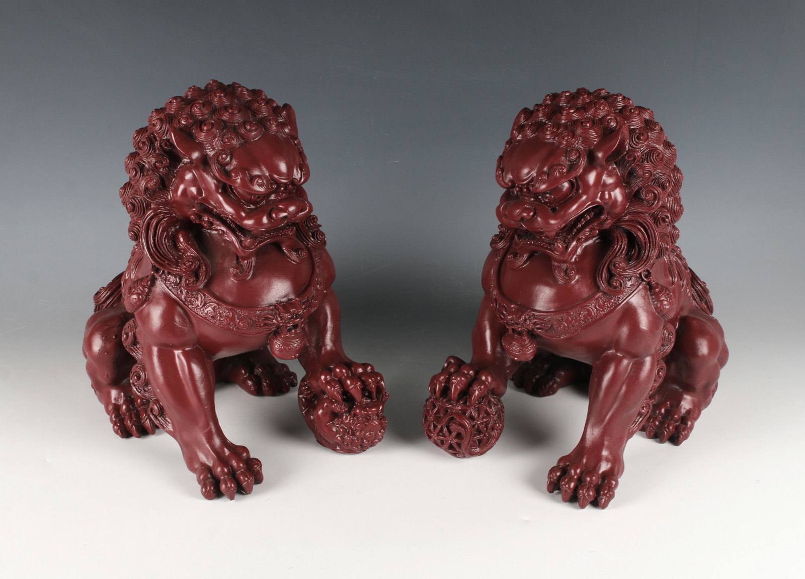 PAIR FOO DOGS SCULPTURES: Dark red foo dogs with detailed hair, eyes, beards, and claws. Ready to guard your domain. 11" X 11 1/2" $100 - $200 Please contact us for high resolution images of this lot. S