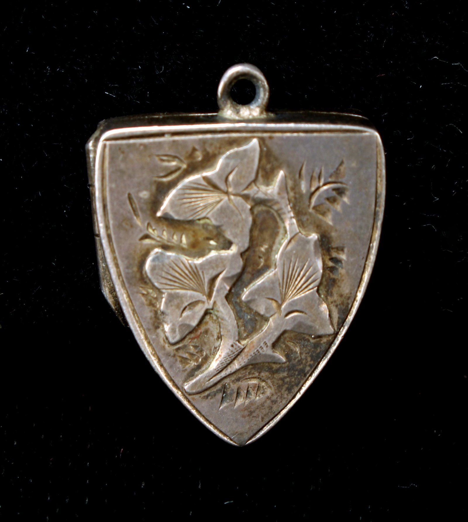 SMALL ANTIQUE LEAF LOCKET PENDANT: In a shield form with leaves on the front. Four hallmarks on back. Loop at top. 1/2" $40 - $80 Please contact us for high resolution images of this lot. Shipping: