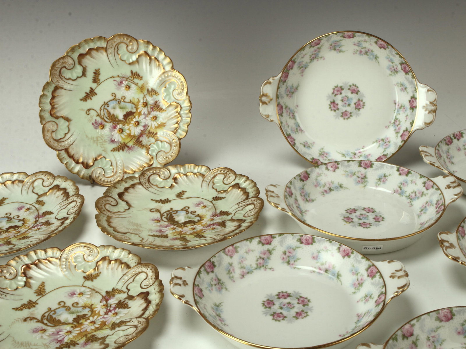 14 ANTIQUE LIMOGES PLATES AU GRATIN: Eight Individual au gratin bowls, and six dessert plates. The gratin bowls have pink roses with accented rims and handles in gold. Marked Limoges and 14 1/2. Small dessert plates are elaborately hand 