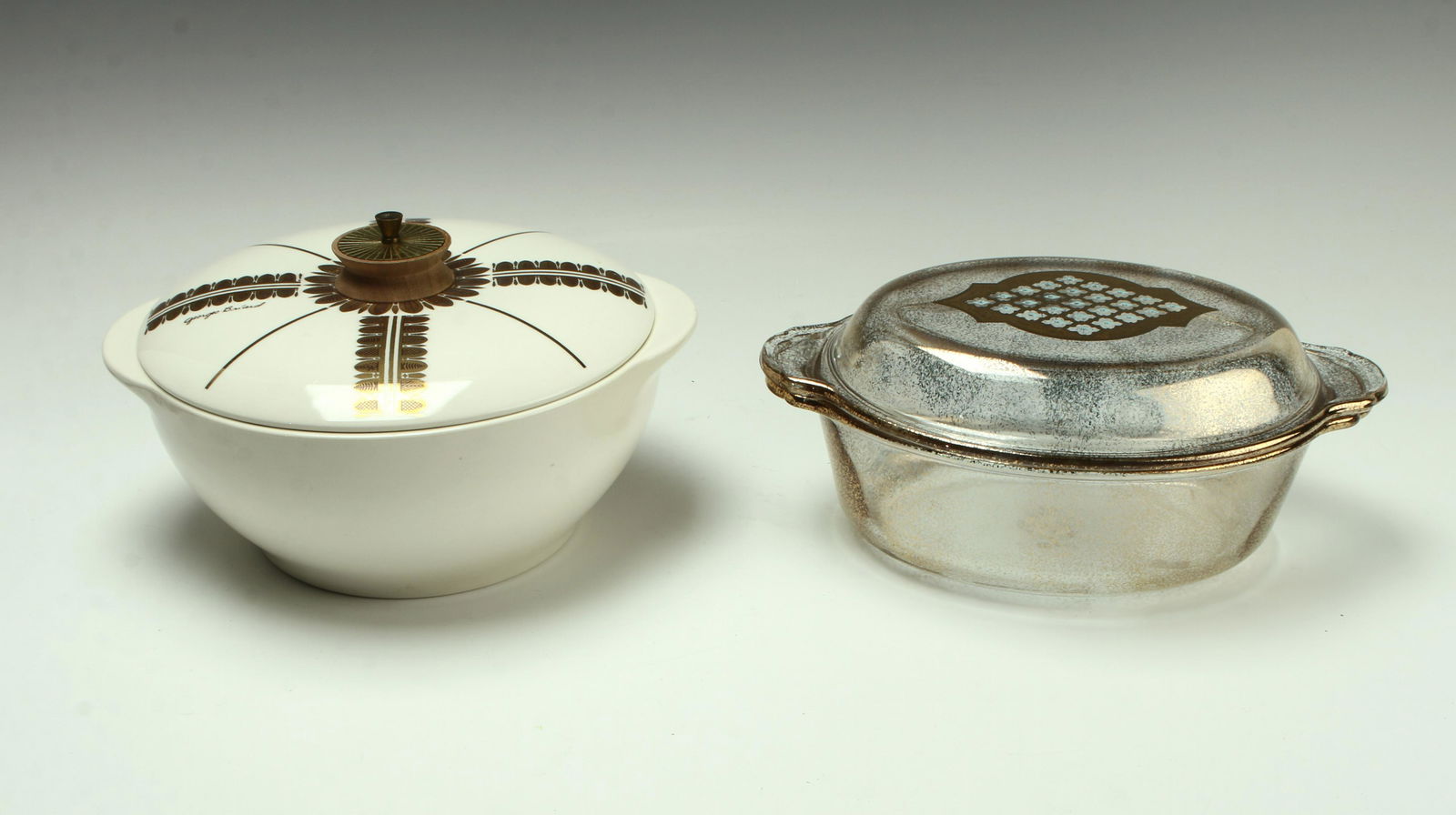 2 VINTAGE MID CENTURY GEORGES BRIARD CASSEROLES: Mid Century Modern covered casserole dishes. One casserole in clear Pyrex with gold patterns and the other in white porcelain with gold radiating patterns and teak handle, marked 2 ½ qt on bott