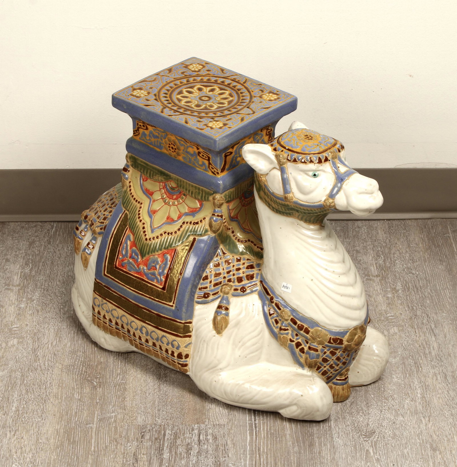 GUMPS PORCELAIN SEATED CAMEL GARDEN PATIO STOOL: White porcelain with multicolor bridle and saddle cloths, tassel and seat. From Gumps San Francisco. 21" X 10" X 16 1/2" $200 - $400 Please contact us for high resolution images