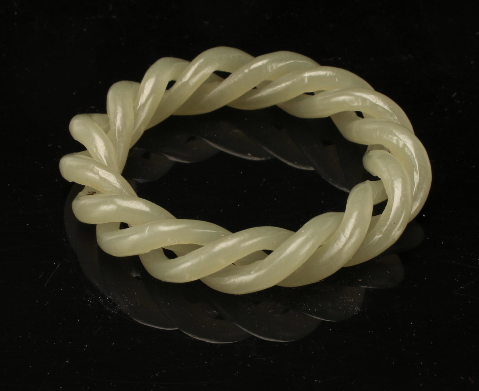 SMALL CHILD'S INTERTWINED BANGLE: Two pieces of hard stone intertwined to create this small bangle. 2" $300 - $500 Please contact us for high resolution images of this lot. Shipping: We are ab