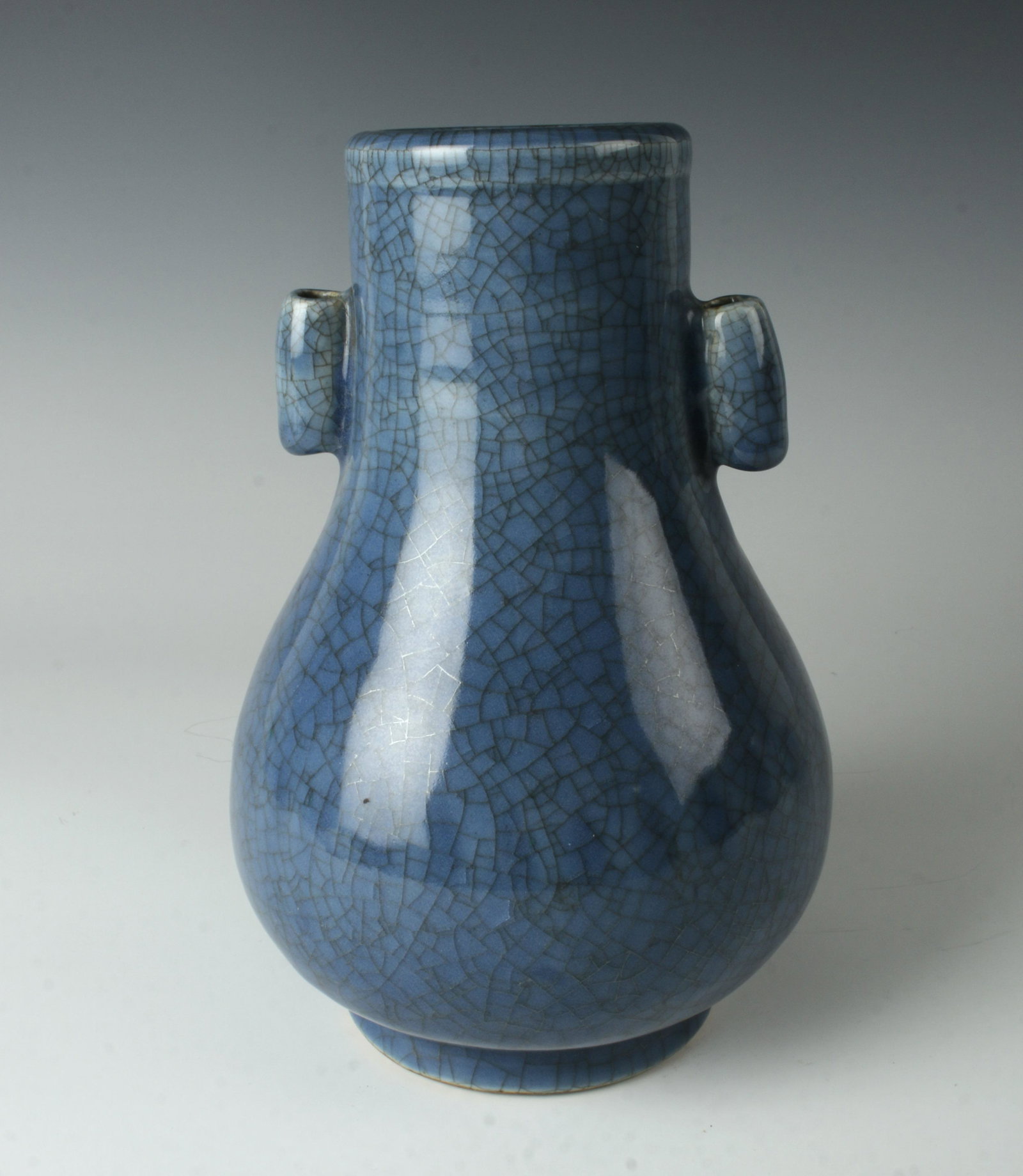BLUE CRACKLE VASE WITH HANDLES: Tubular handles on either side of the neck, the body curves out. Soft slate blue with an all over craquelure. 5 1/2" X 8 1/2" $400 - $600 Please contact us for high resolution images