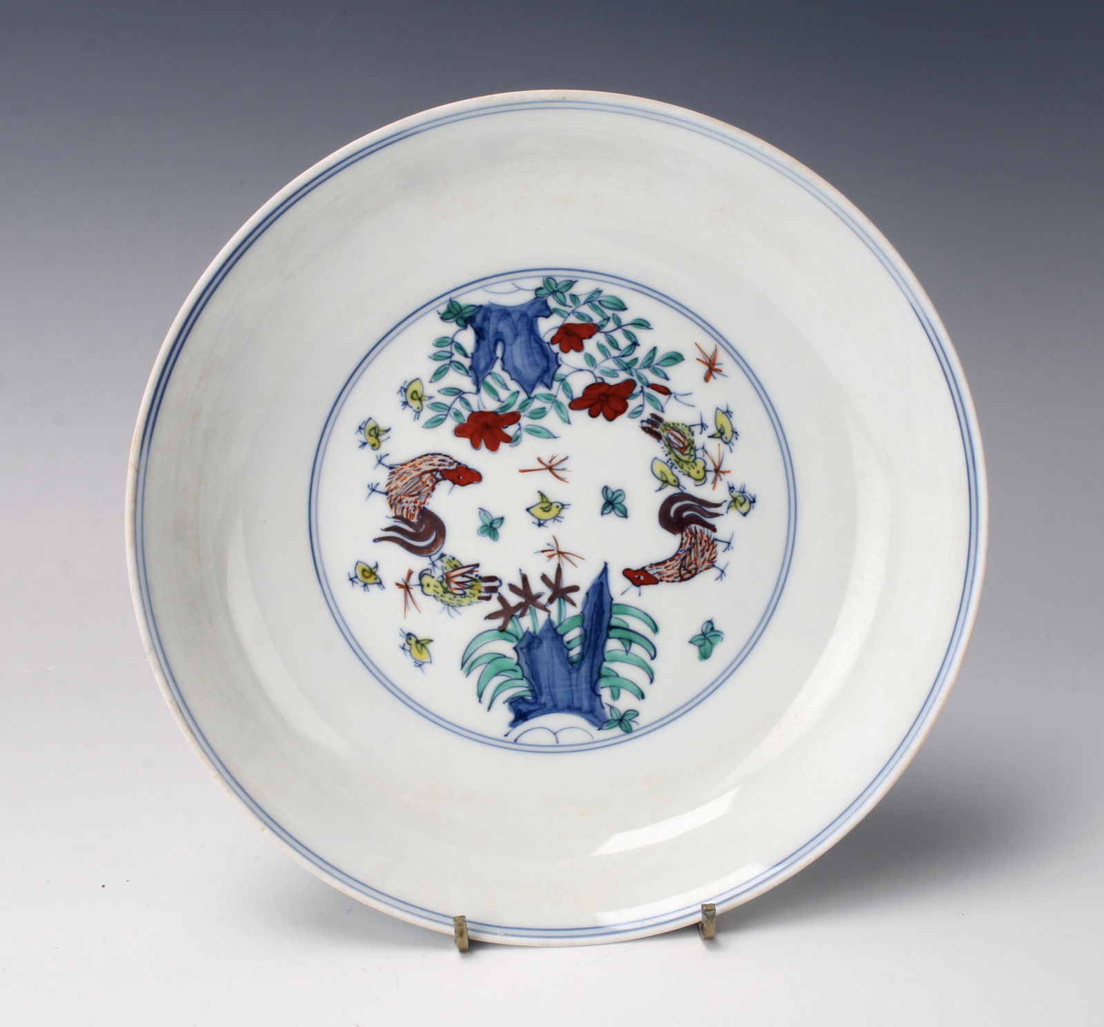 CHINESE PORCELAIN ROOSTER BOWL: In thin porcelain. The center has scene with roosters and chicks, boulders and flowers complete the garden. Outside rim has boulders, flowers, roosters, hen, and chicks. Marked on bottom. 8 1/2"