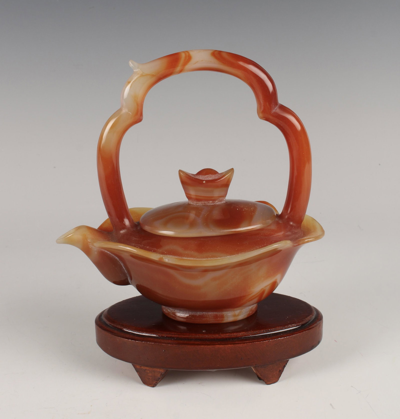 AGATE TEA POT ON STAND: Finial shaped like an ingot on the lid. Carved and polished. 7 1/2" x 6" x 4" $400 - $600 Please contact us for high resolution images of this lot. Shipping: