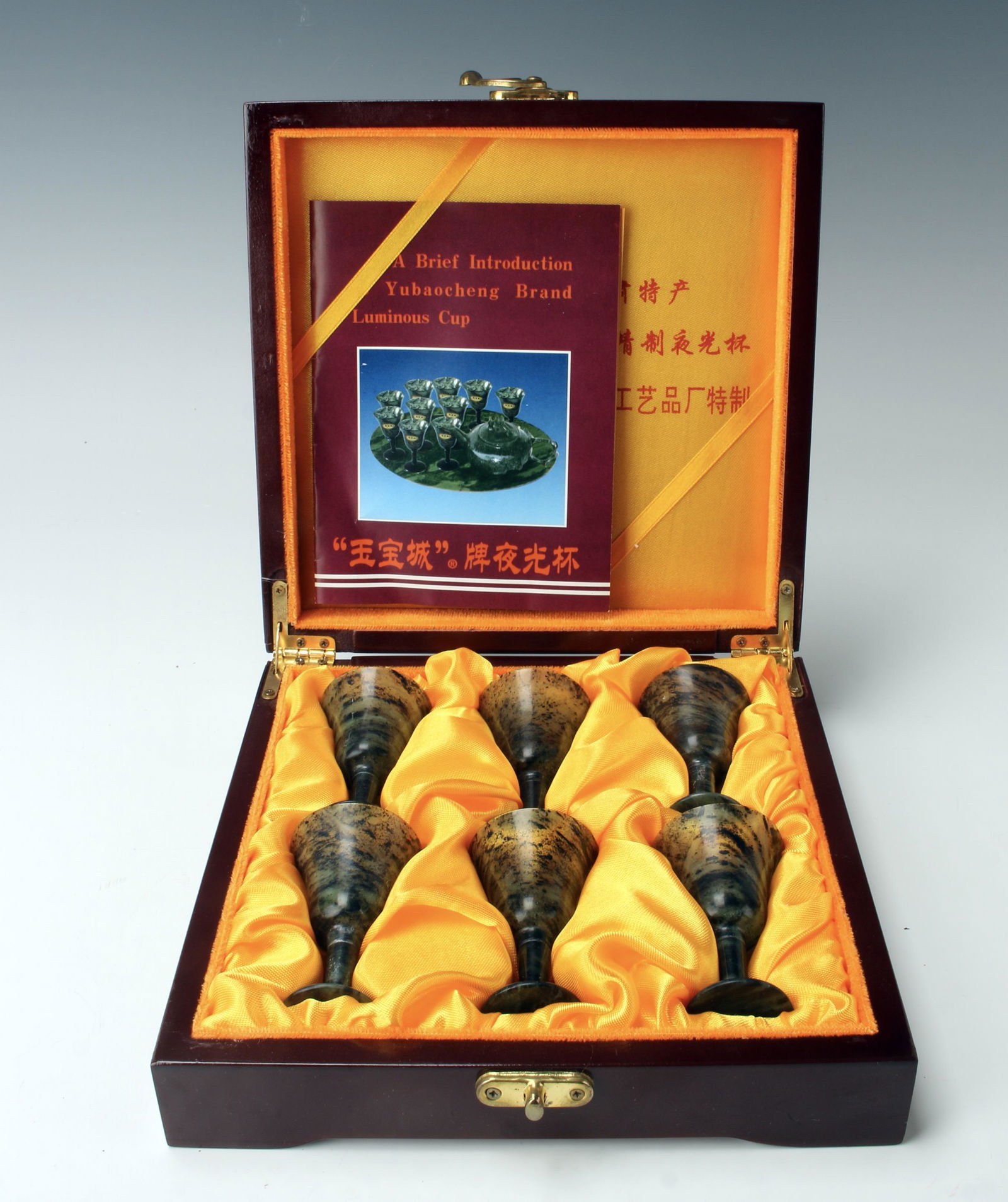 6 HARD STONE CUPS IN BOX: Six green hard stone cups in presentation box with calligraphy on lid. 7 1/4" X 7 1/2" X 2" $300 - $500 Please contact us for high resolution images of this lot. Shipping:
