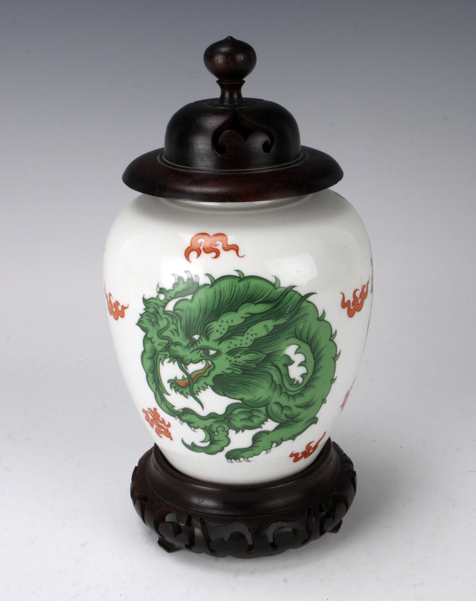 GREEN DRAGON GINGER JAR W WOODEN STAND & LID: Bright green dragon surrounded by orange bats. On a carved and pierced wooden stand with a wooden lid. Marked Fitz & Floyd Inc. "Dragon Crest" 1975. 4 1/2" X 9" $40 - $80