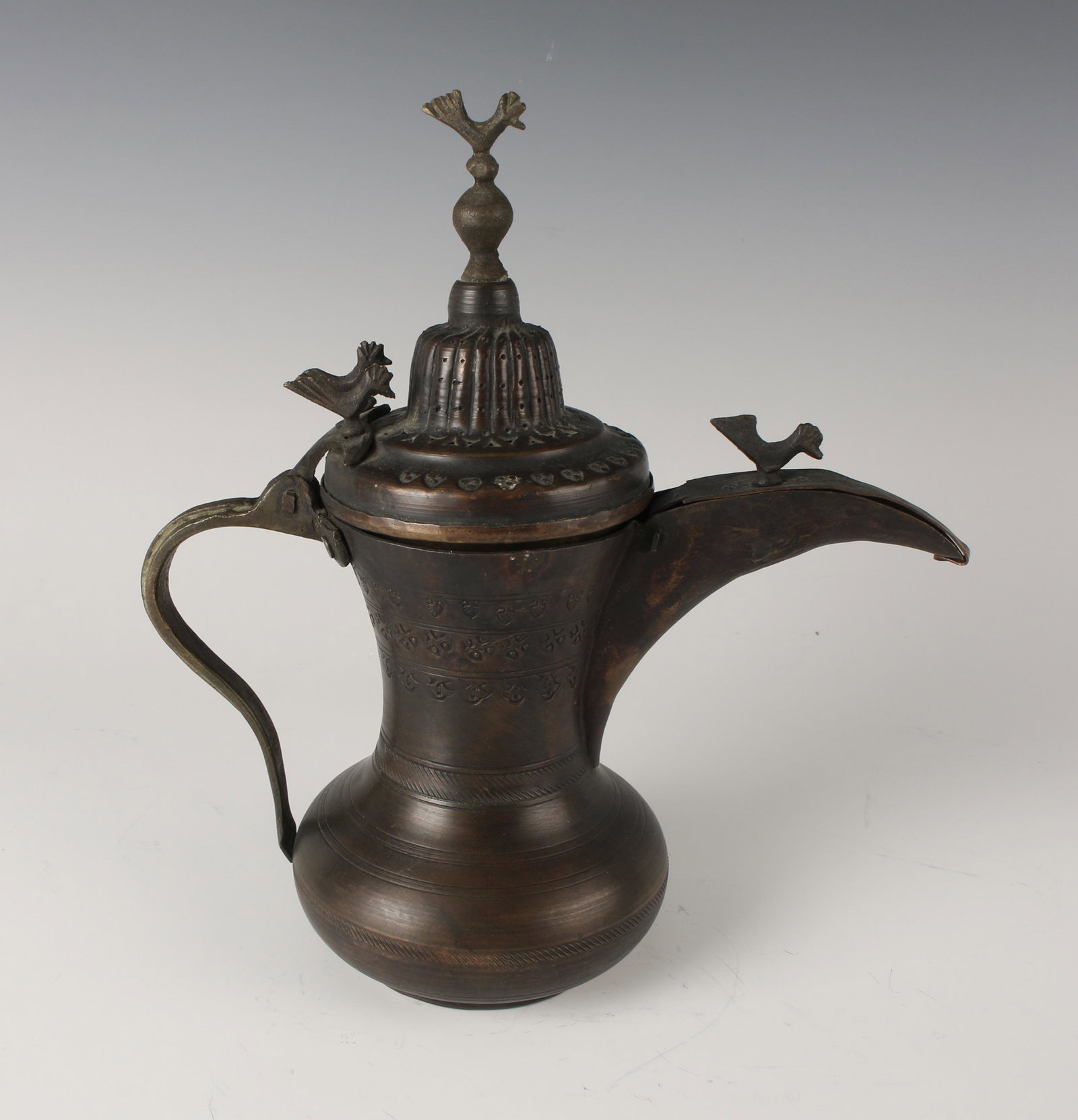 JORDANIAN STYLE COPPER COFFEE POT: With rooster finial on lid. Four roosters on top. Fly guard cover of spout. Stamped and pierced decorations. Circular bands and upper register of arabesque stamped floral designs. 8" X 9"