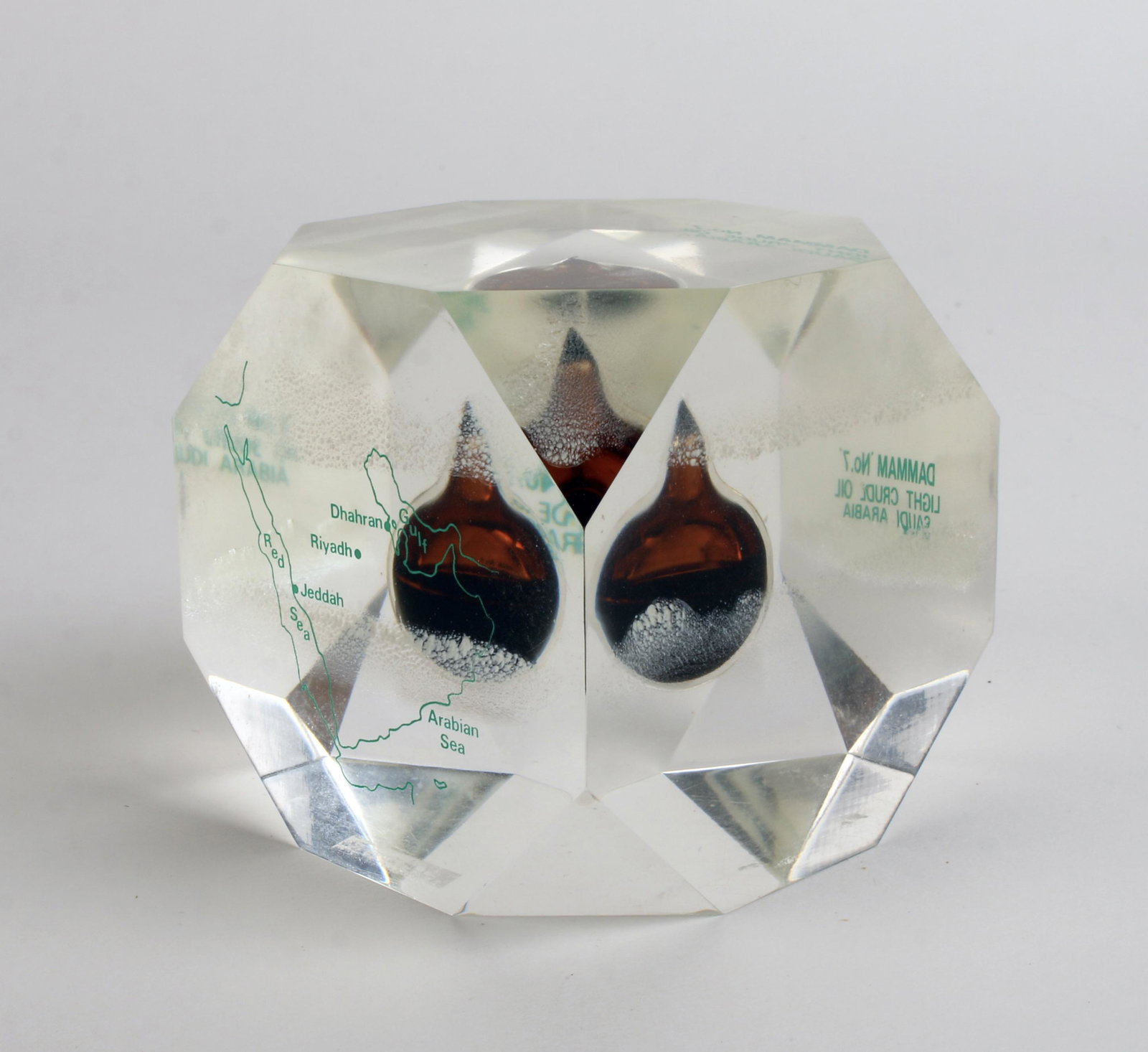 LUCITE PAPERWEIGHT WITH SAUDI ARABIAN OIL: With oil from "Dammam #7" the first commercial oil well in Saudi Arabia drilled in 1936 by Aramco. 2 1/2" $100 - $200 Please contact us for high resolution images of this lot.