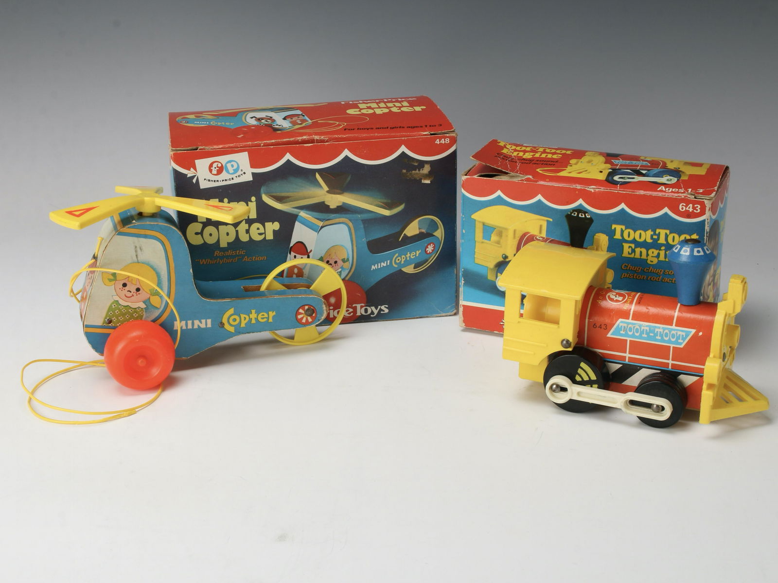 FISHER PRICE MINI COPTER TOOT TOOT ENGINE IN BOX: 1970 Mini Copter No. 448 pull toy. 1972 Toot-Toot Engine No. 643. 7 1/2" X 5 1/2" X 4" $100 - $200 Please contact us for high resolution images of this lot. Shipping:<