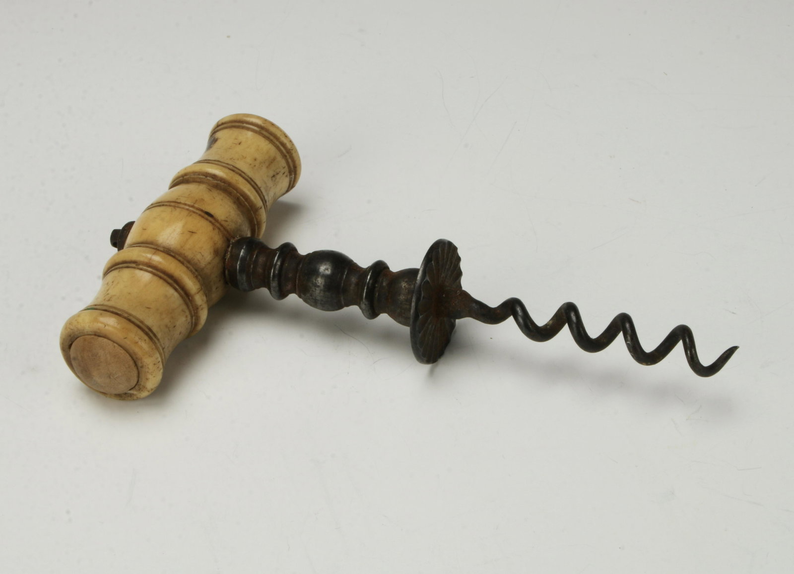 ANTIQUE BONE HANDLE CORKSCREW: Forged metal bottom. Handle in barrel form. 3 1/4" X 5 1/2" $40 - $80 Please contact us for high resolution images of this lot. Shipping: We are able to