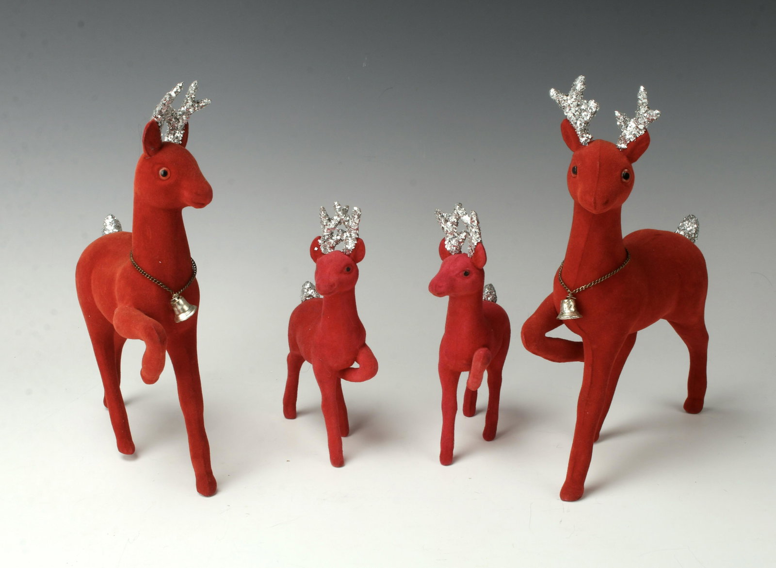 4 VINTAGE RED FLOCKED REINDEER: The two larger deer have bells around their necks. Glitter tails and antlers. Labeled Made in Japan. 6 1/2" $40 - $80 Please contact us for high resolution images of this lot. Shipp